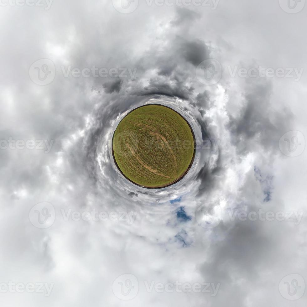 tiny planet in blue sky with beautiful clouds. Transformation of spherical panorama 360 degrees. Spherical abstract aerial view. Curvature of space. photo