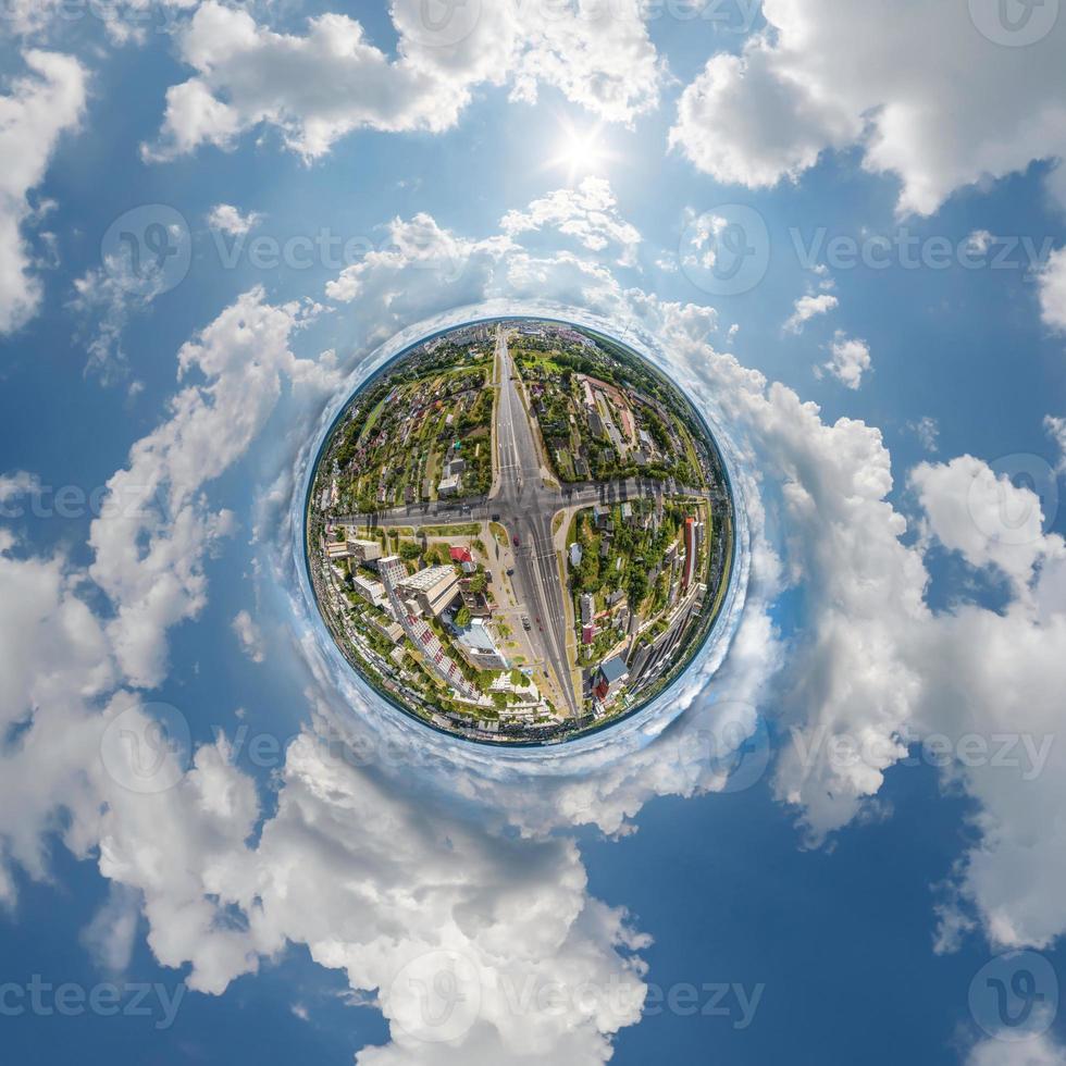 tiny planet in sky with clouds overlooking old town, urban development, historic buildings and crossroads. Transformation of spherical 360 panorama in abstract aerial view. photo