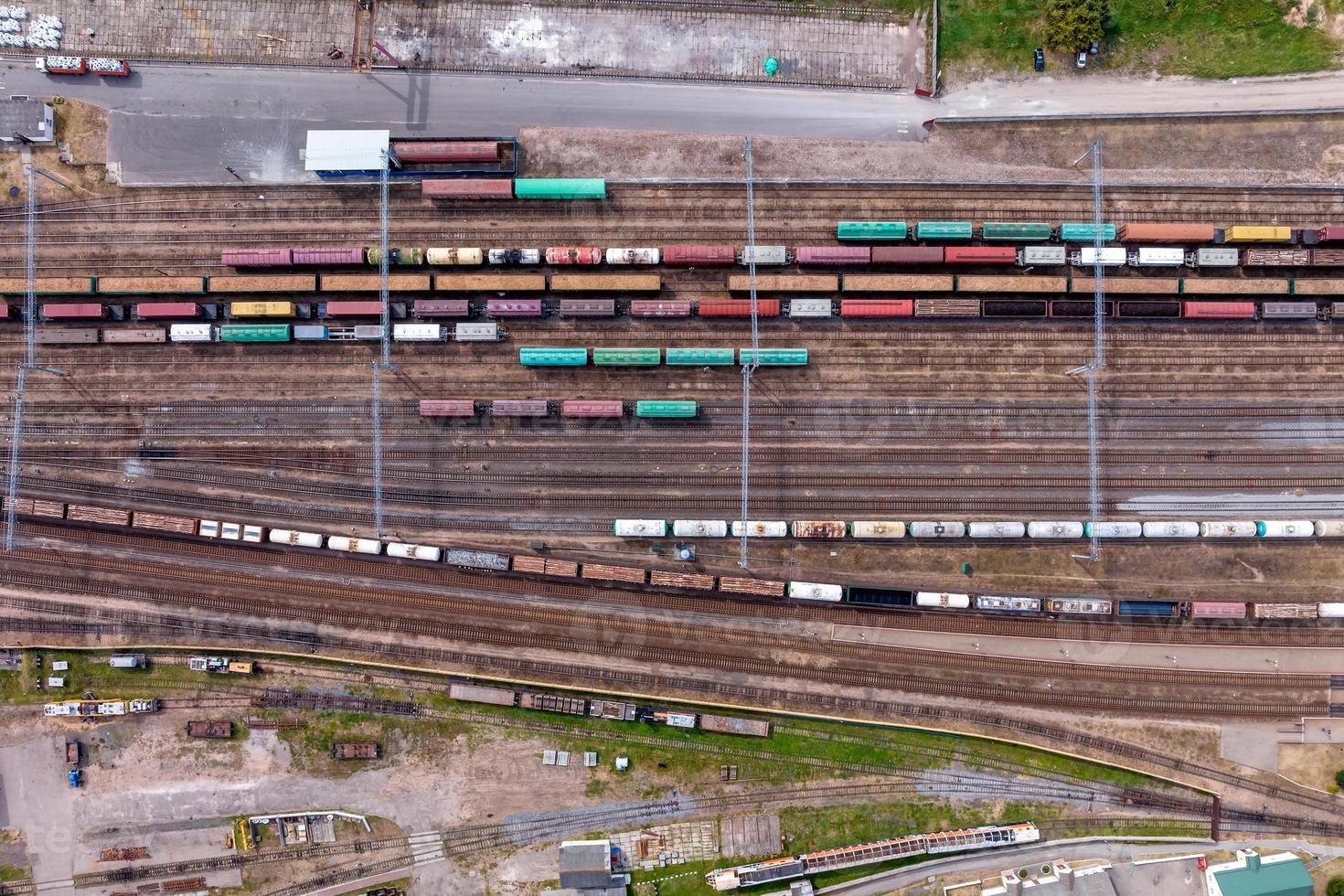 aerial view over long railway freight trains with lots of wagons stand on parking photo