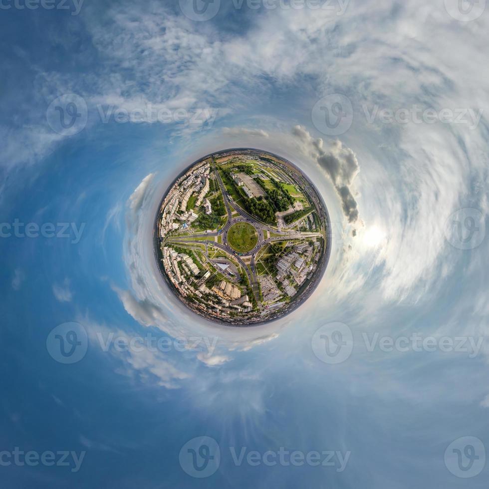 tiny planet in sky with clouds overlooking old town, urban development, historic buildings and crossroads. Transformation of spherical 360 panorama in abstract aerial view. photo