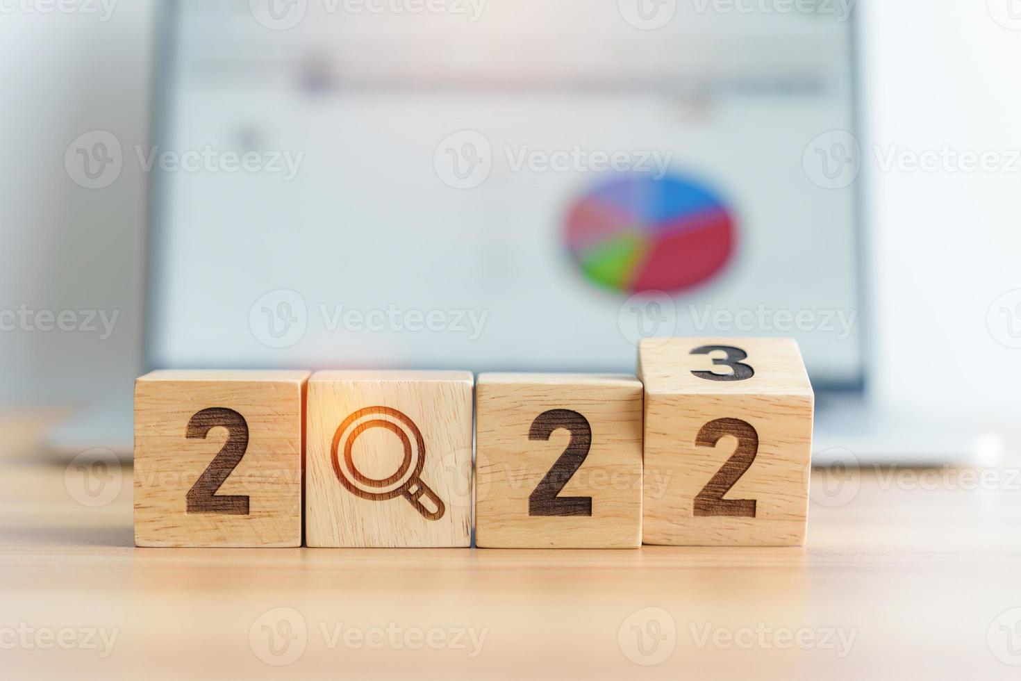 2023 block with magnifying glass icon against laptop background. Hiring, recruitment, job, jobless SEO, Search Engine Optimization and New Year concepts photo