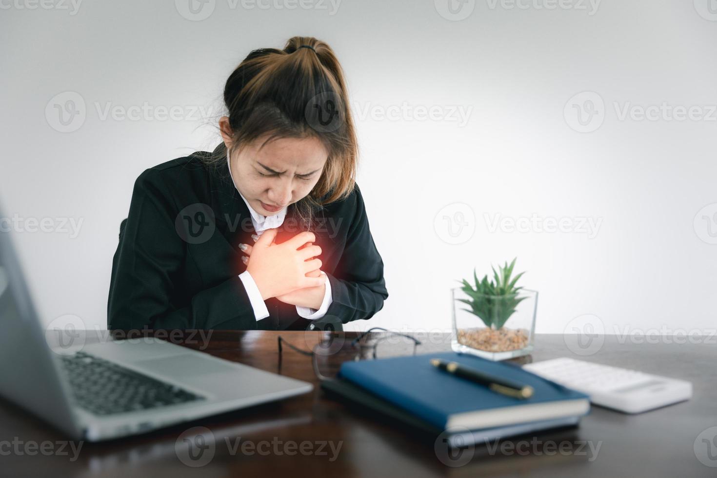 Woman touching breast and having chest pain after long hours work on computer. Office syndrome, Risk of occupational burnout stress syndrome in heart attack disease of asian people concept. photo