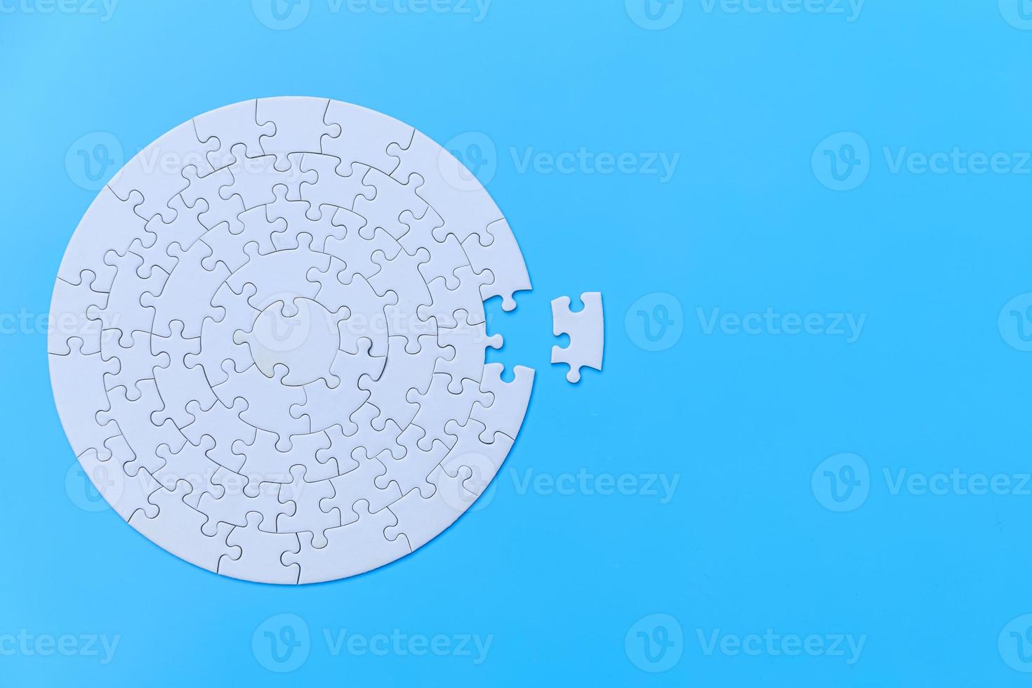 White jigsaw puzzle on a blue background. Completing final task, missing jigsaw puzzle pieces and business concept with a puzzle piece missing. photo