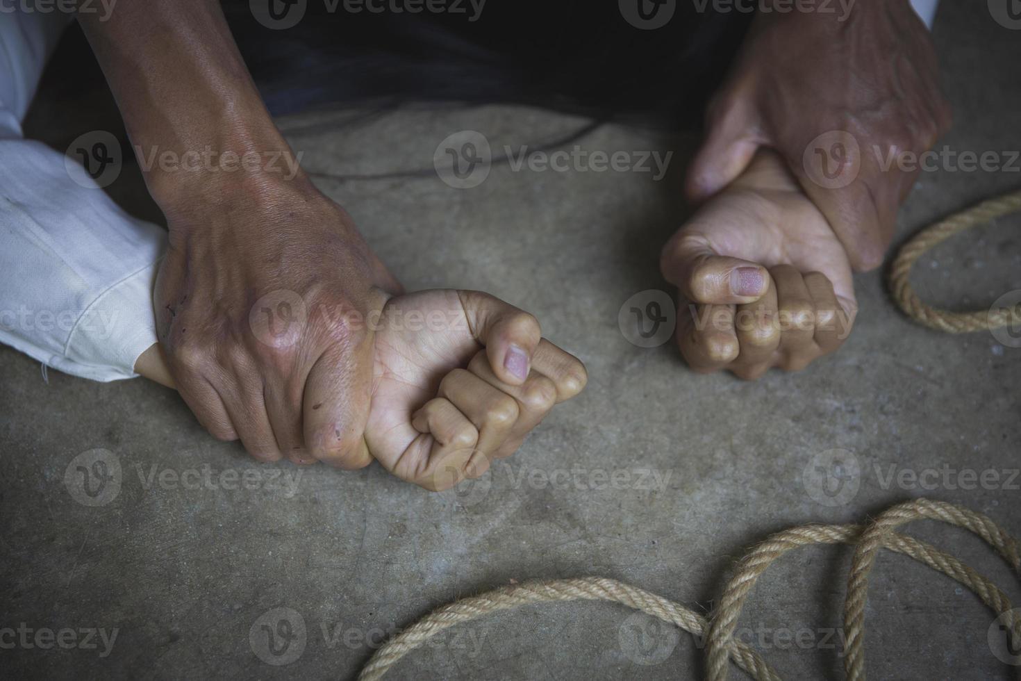 Man hands holding a woman hands for rape and sexual abuse concept. Stop sexual harassment and violence against women. International Women's Day. photo