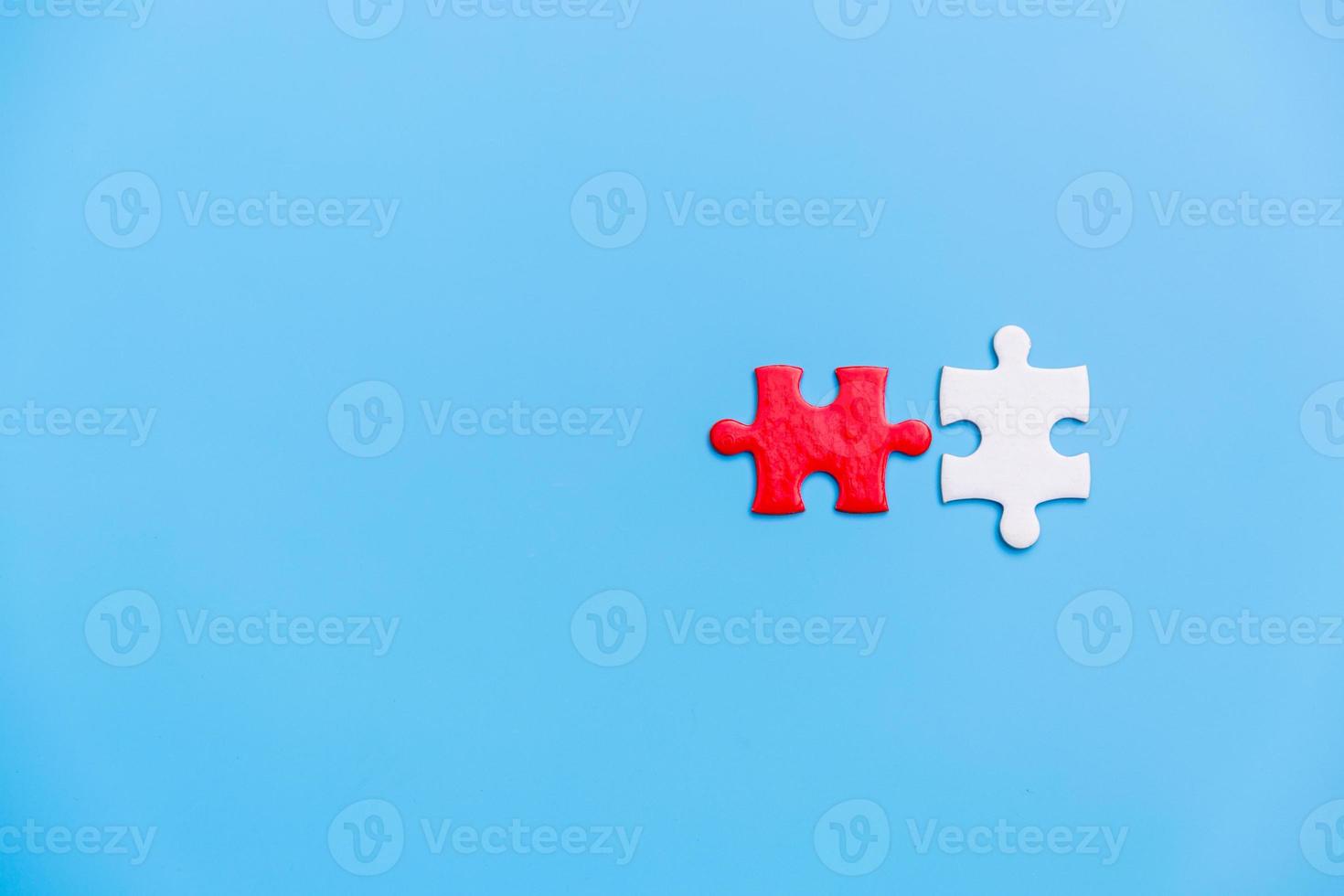 White and red jigsaw puzzle on a blue background. Copy space for text, top view, close up. photo
