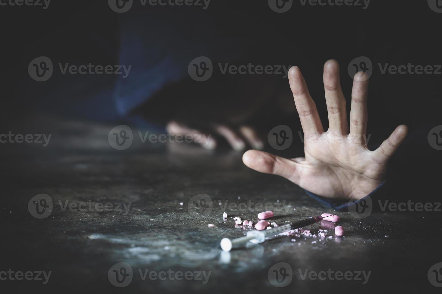 Man ddict with a syringe using drugs on the floor . Drugs addiction and withdrawal symptoms concept. drugsInternational Day against Drug Abuse. photo