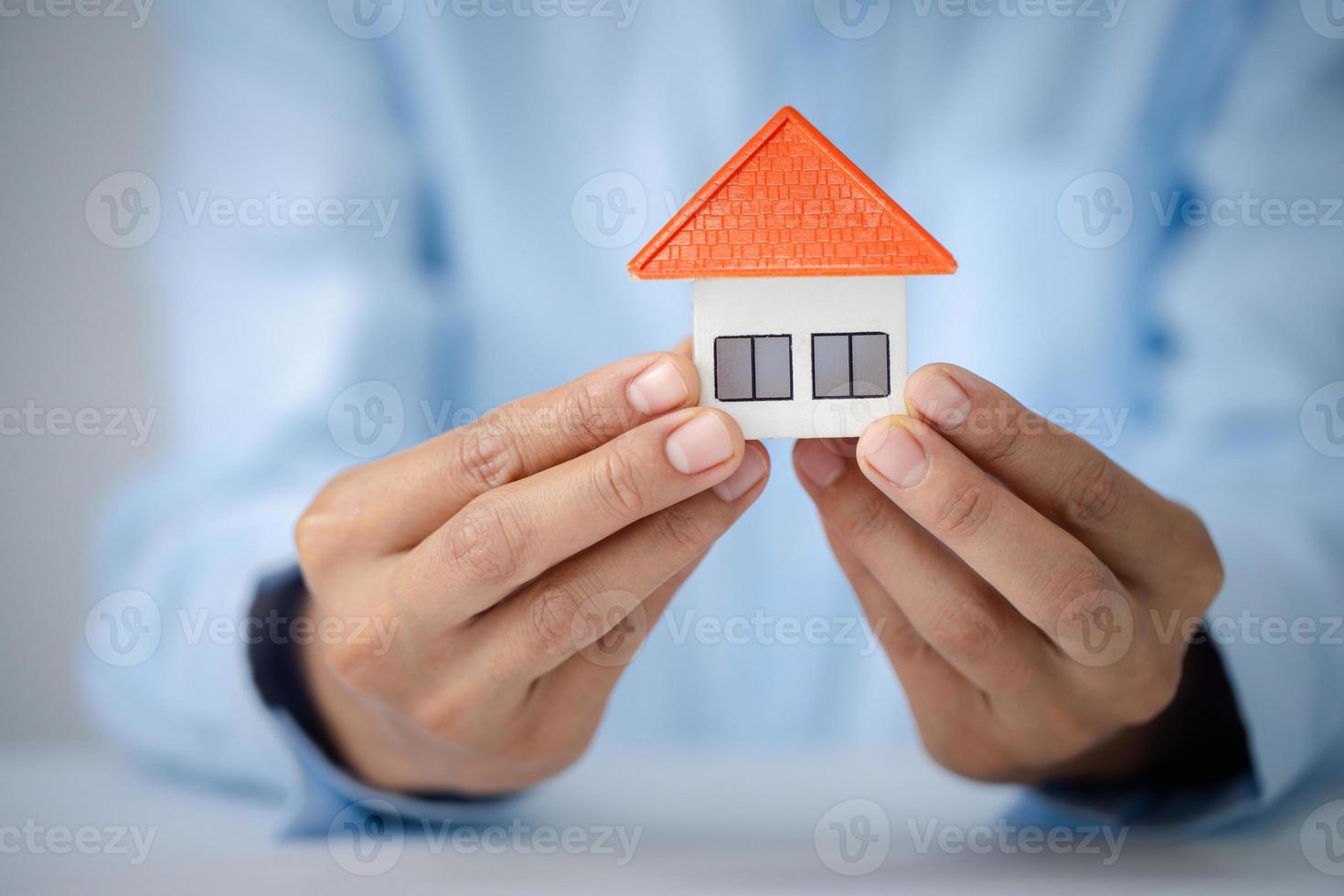 Real estate agent with house model, Home sales and home insurance concept. photo