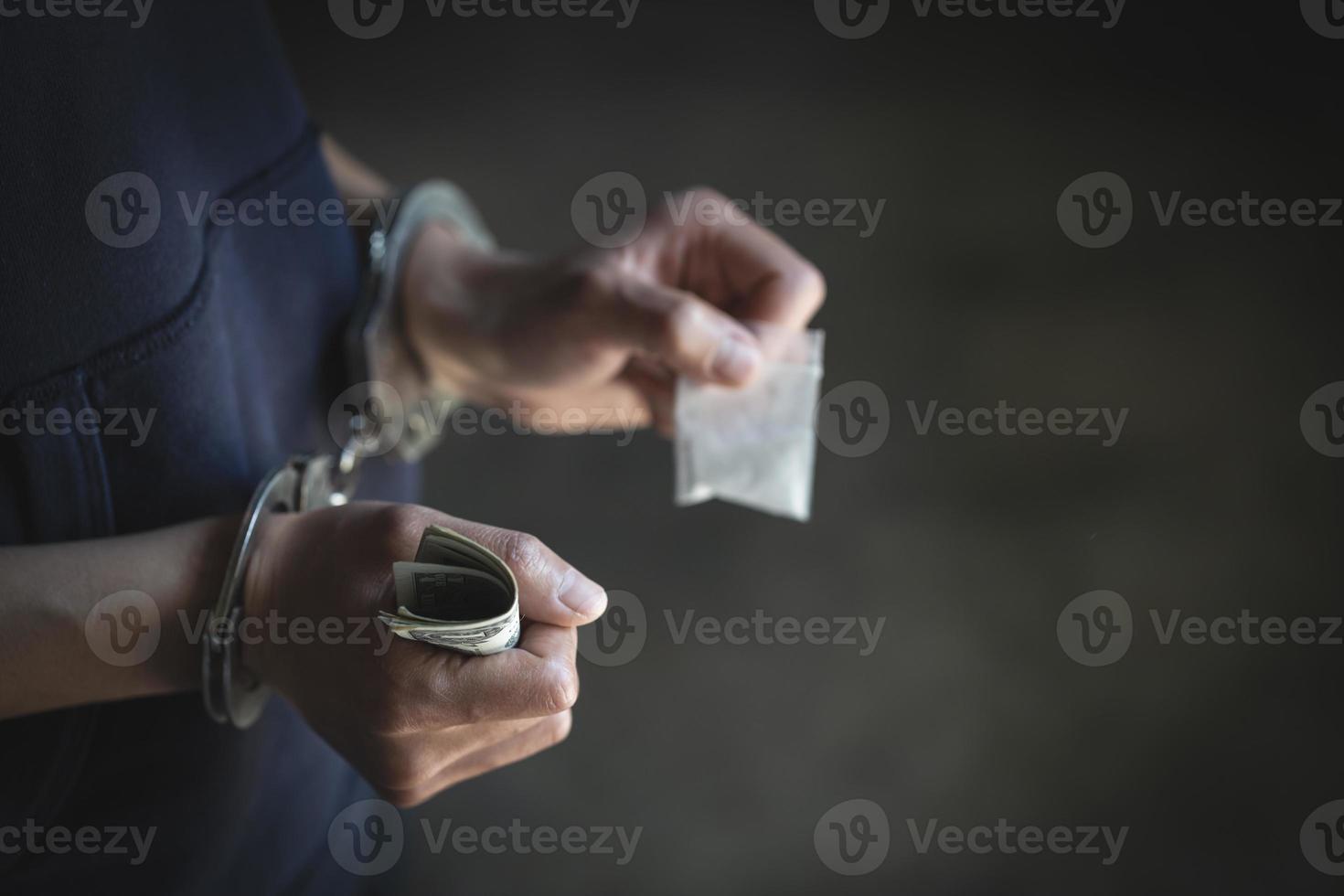 Drug dealer under arrest confined with handcuffs.   Anti drug.  Drug concept. photo