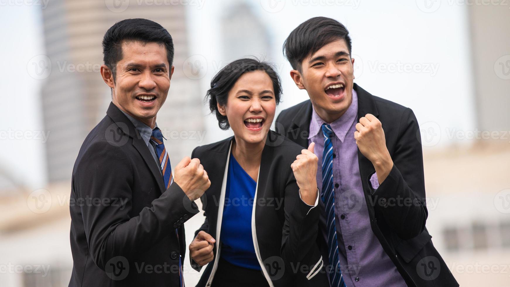 hombres y mujeres de negocios asiáticos expresan alegría y felicidad en el trabajo exitoso fuera de la oficina foto