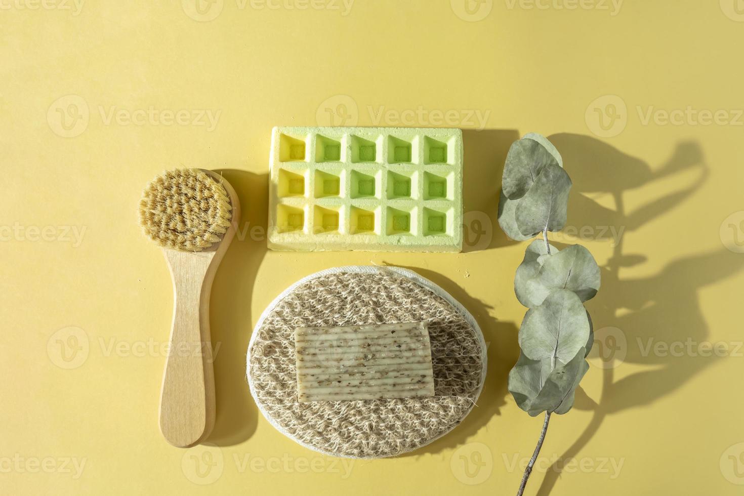 A body care brush, a massager, a natural soap and a bath bomb for spa procedures lying on a colorful background photo