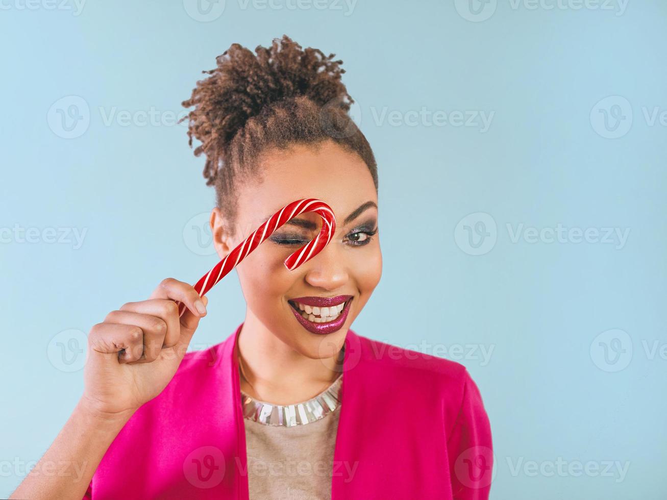 cheerful and happy afro american woman with candy cane. Christmas, new year, sugar, happiness, holidays concept photo