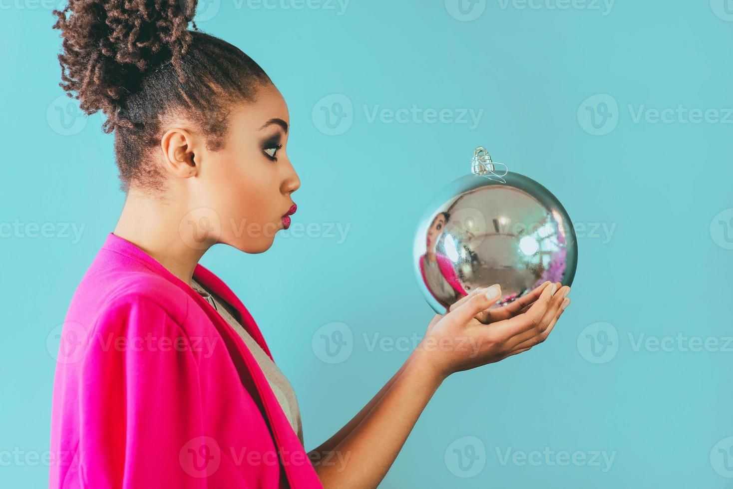 cheerful afro american woman holding in her hands christmas bauble decoration. Christmas, new year, happiness, holidays concept photo