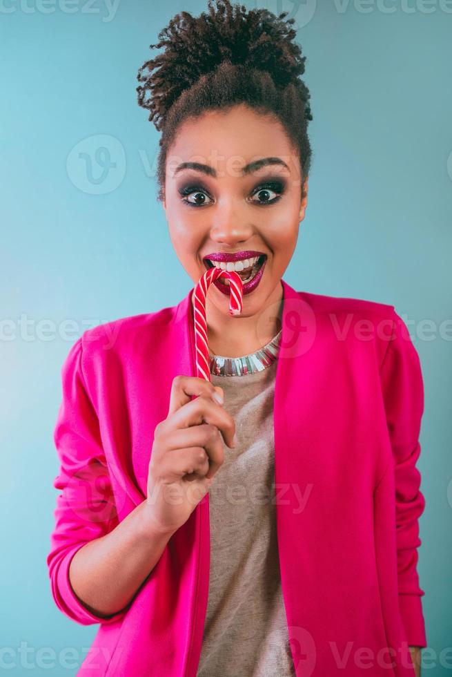 cheerful and happy afro american woman with candy cane. Christmas, new year, sugar, happiness, holidays concept photo