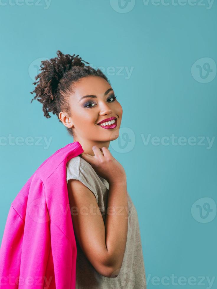 Retrato de una bella y atractiva joven sonriente, alegre, mixta, con chaqueta rosa foto