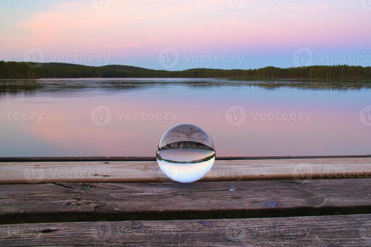 bola de cristal en un muelle de madera en un lago sueco a la hora de la tarde. naturaleza escandinavia foto