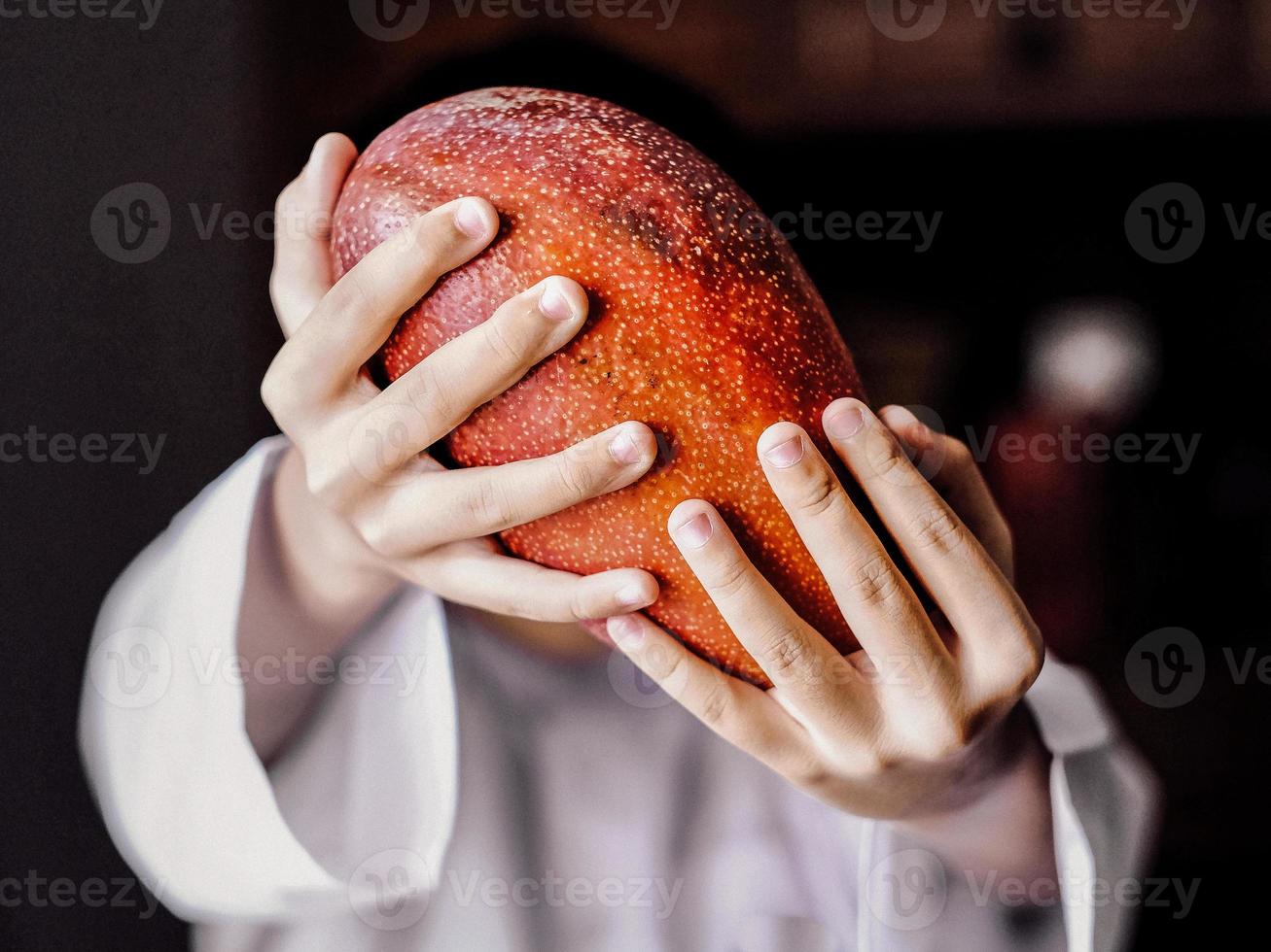 vista cercana de un hombre que sostiene el mango japonés rojo expansivo foto
