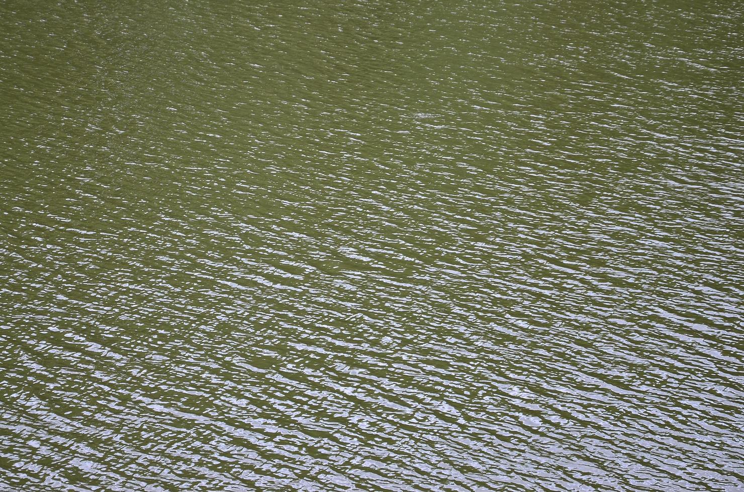 The texture of dark river water under the influence of wind, imprinted in perspective. Horizontal image photo