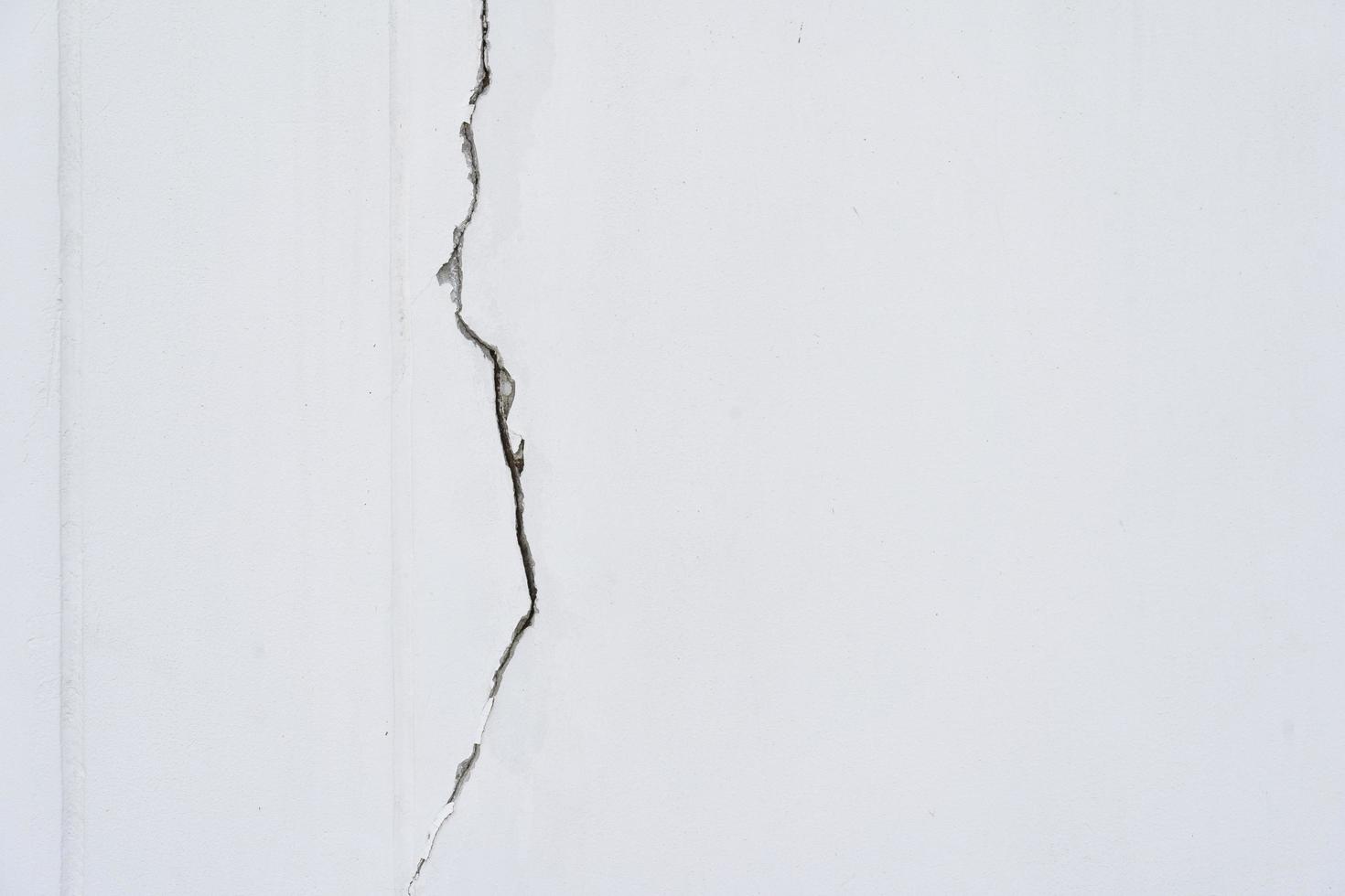 house broken. concrete crack. Water damage building interior. large crack white concrete wall photo