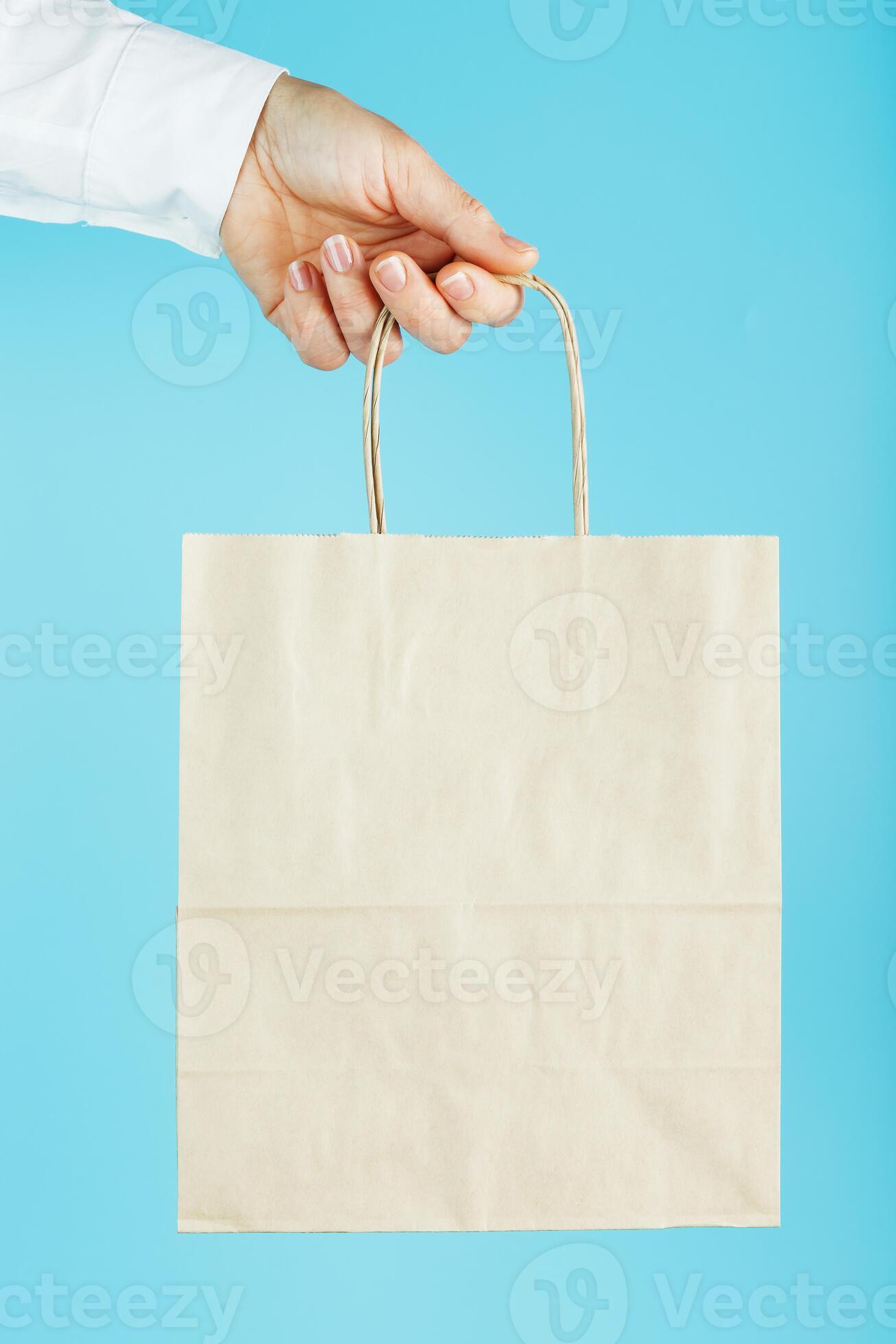 Paper bag at arm's length, brown craft bag for takeaway isolated on