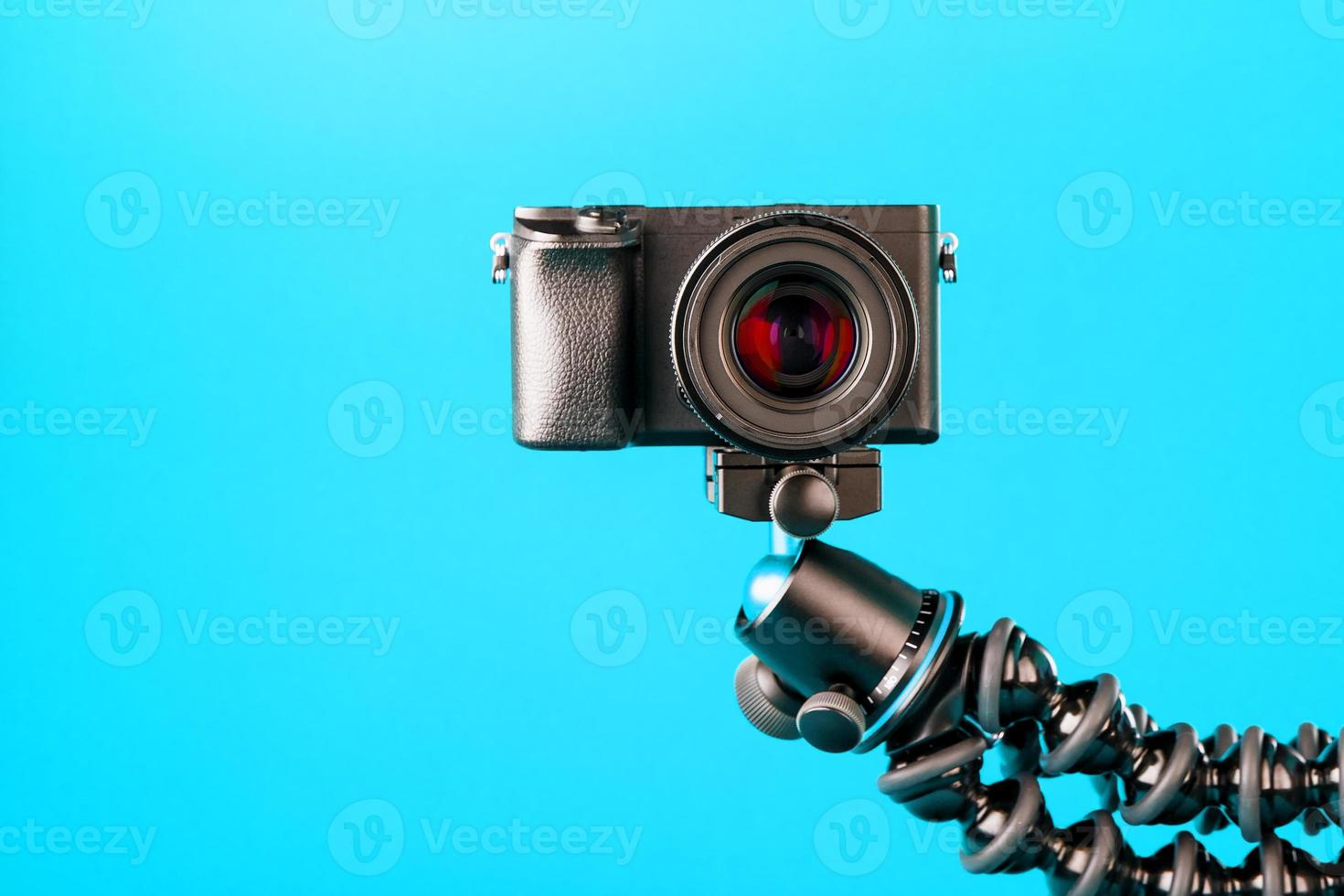 Camera on a tripod, on a blue background. Record videos and photos for your blog or report.