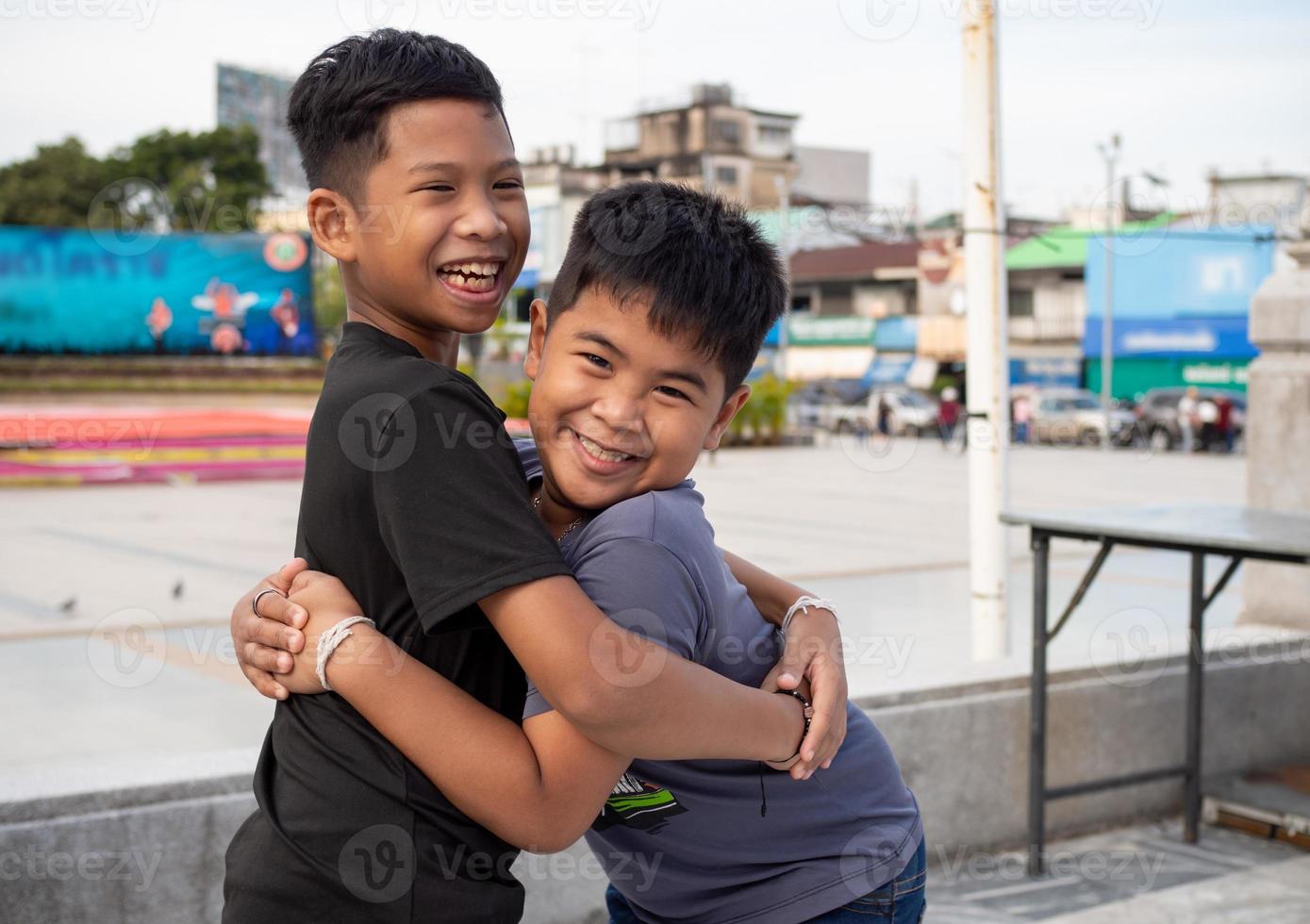 Brothers hugging each other and smiling happily photo