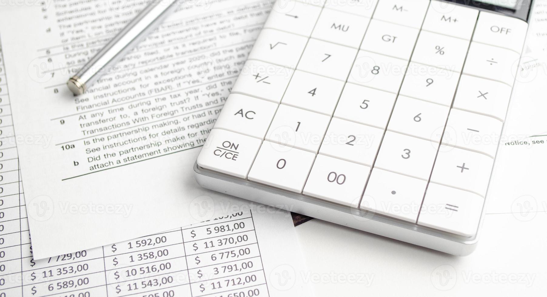 Business concept - financial report and pen, calculator and charts photo