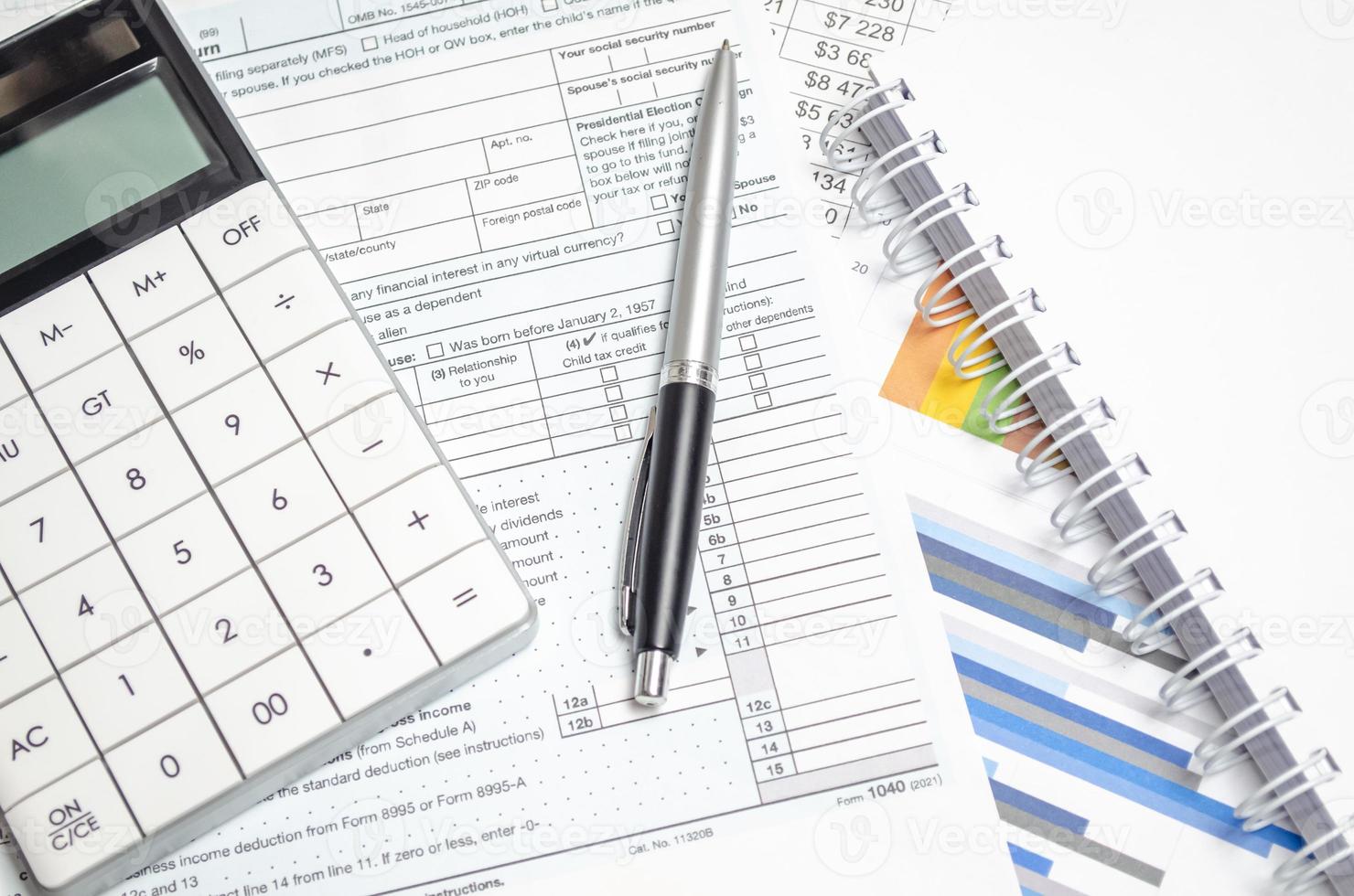 US Individual Tax Return Form 1040 with calculator, pen and charts photo