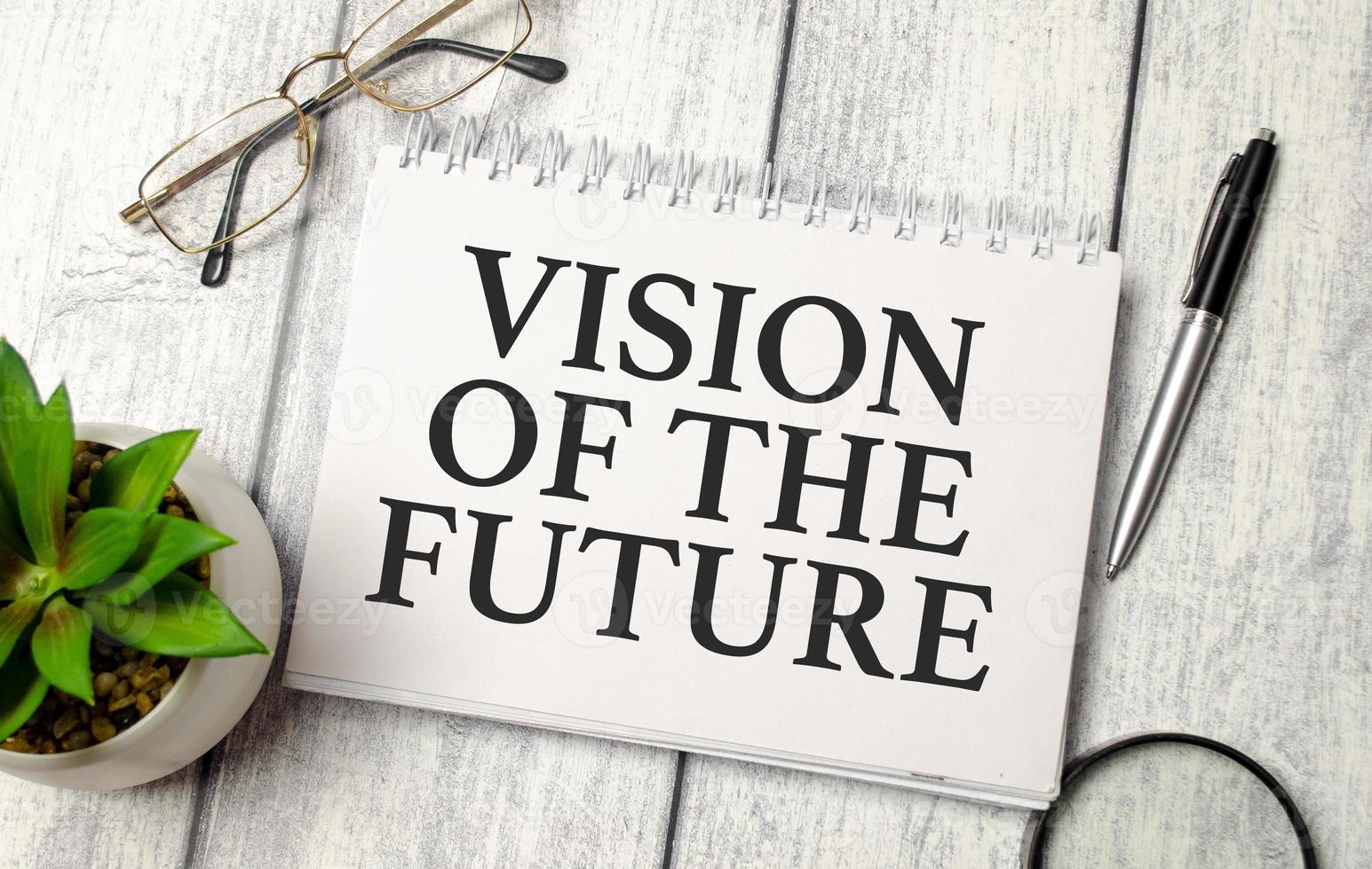 word Vision Of The Future on notepad and wooden background photo