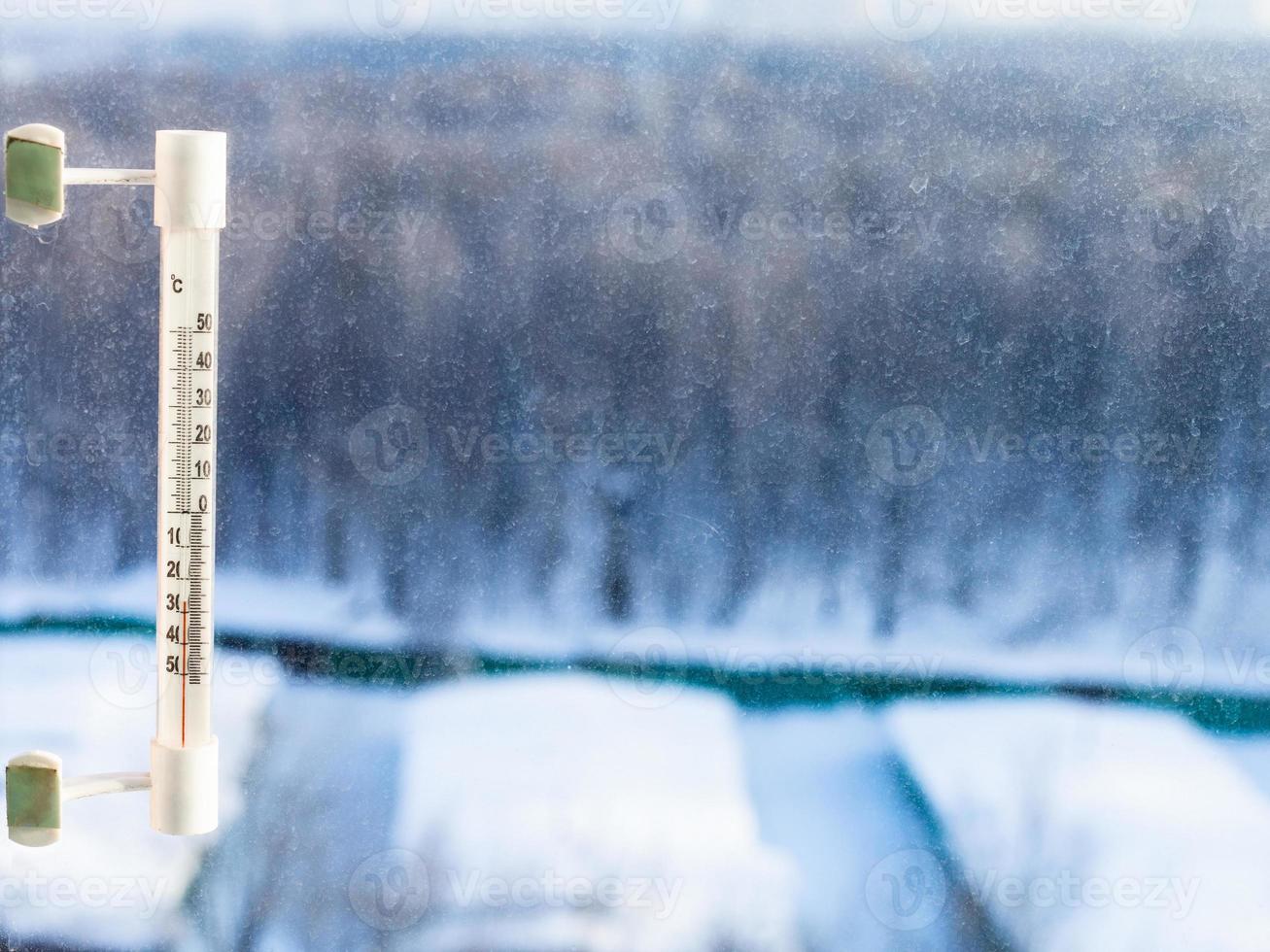 thermometer on home window in cold winter day photo