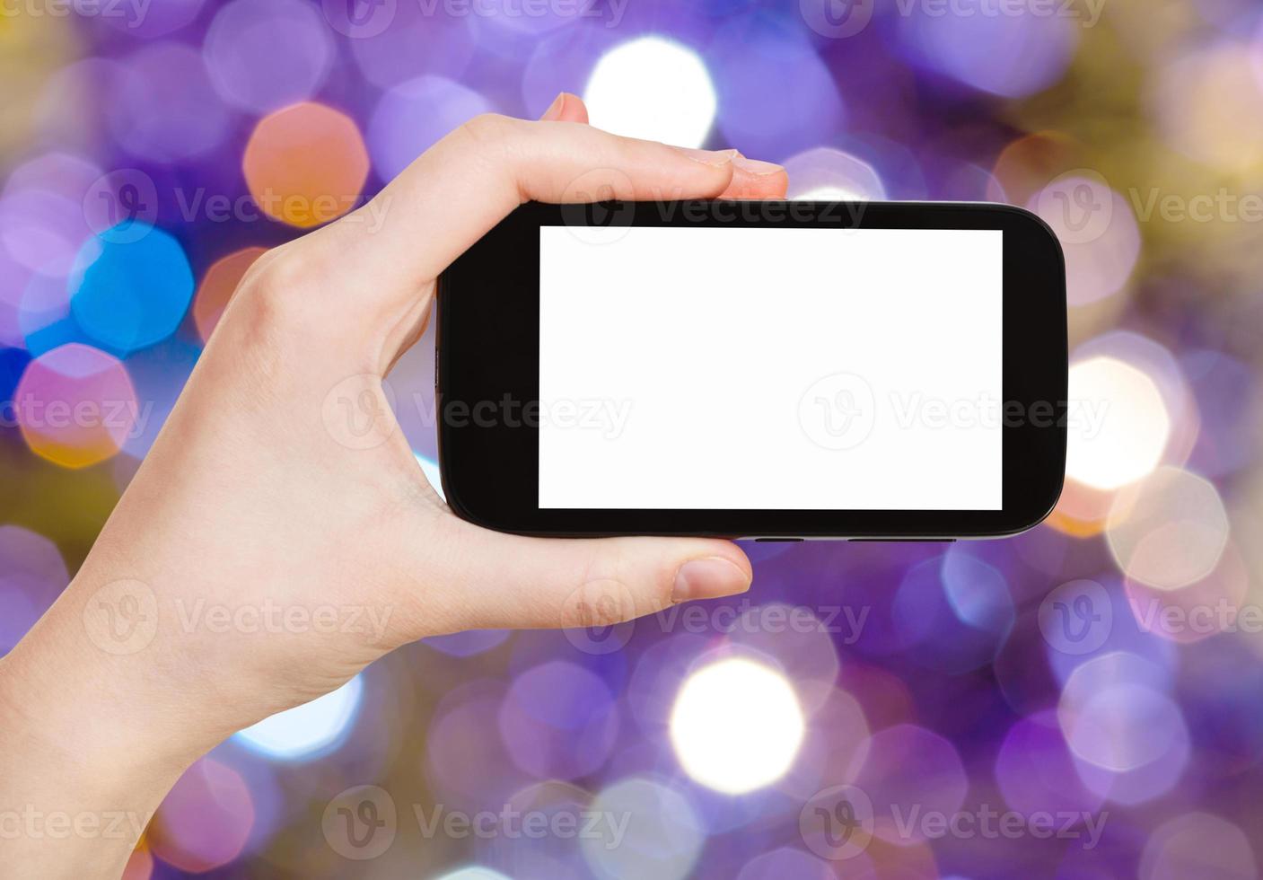 hand with smartphone on blurred violet background photo
