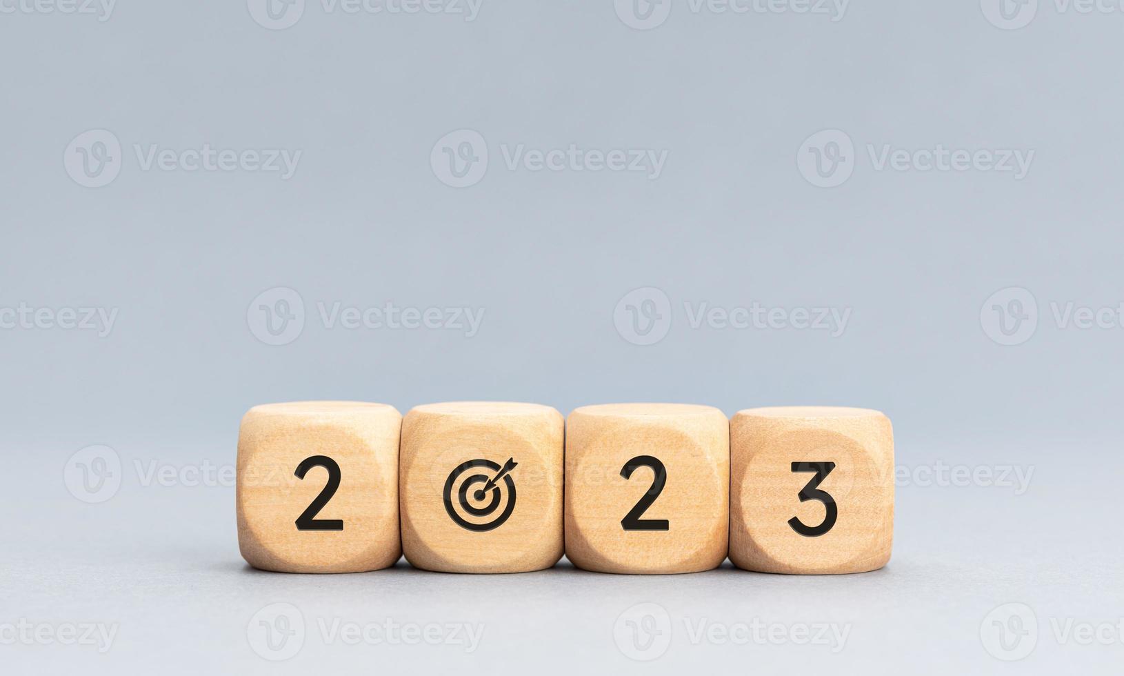 2023 year goals concept. Wooden blocks with 2023 number and goal target icon on gray background. Copy space photo
