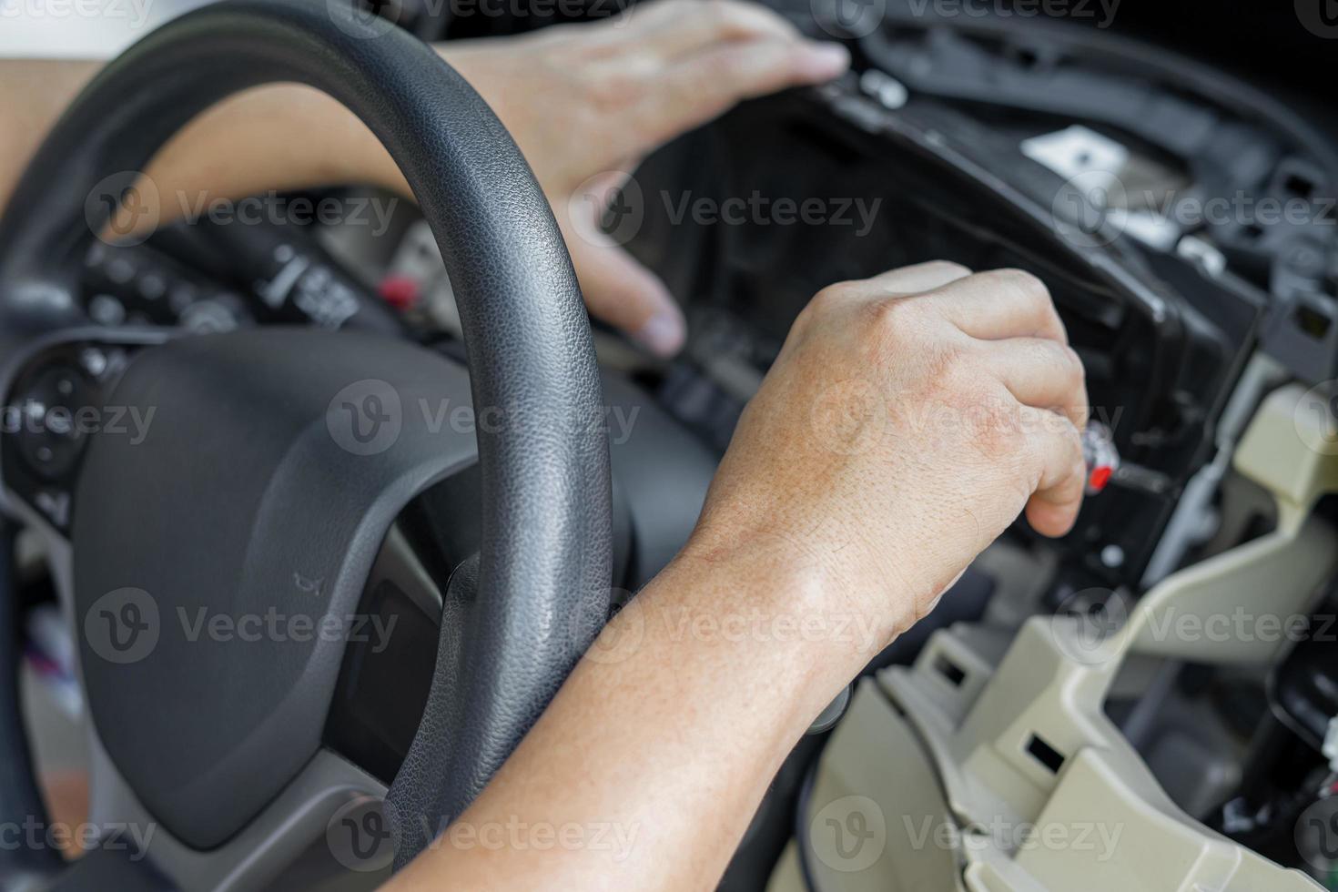 Close up hand Technician use screw driver remove and check car speedometer check the point of damage and check for repair in car service shop photo