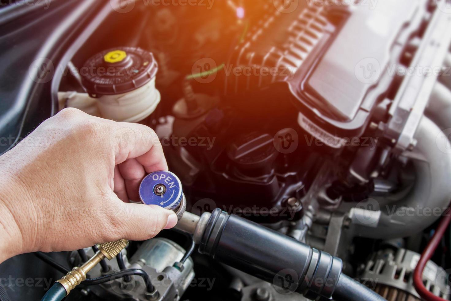 Close up and Technician setting plug of Air refill kit for car repair air  condition maintenance concept in car repair shop photo