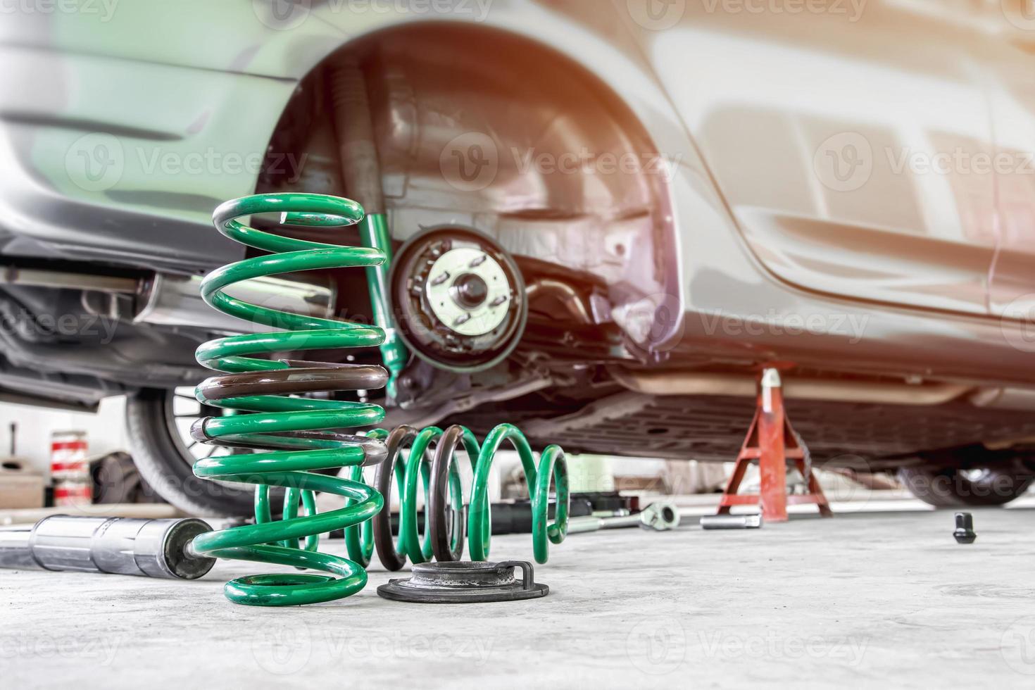 el muelle helicoidal y el amortiguador en el taller de servicio cambian y eliminan el concepto de mantenimiento del coche de piezas antiguas foto