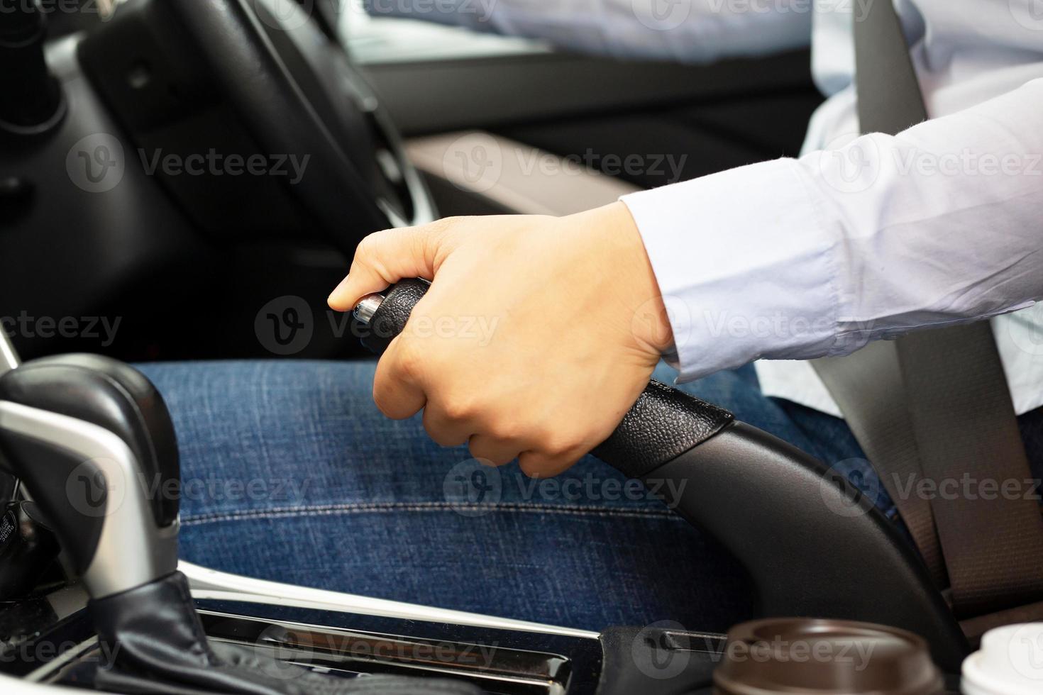 A woman parking a car with a hand brake for safety photo