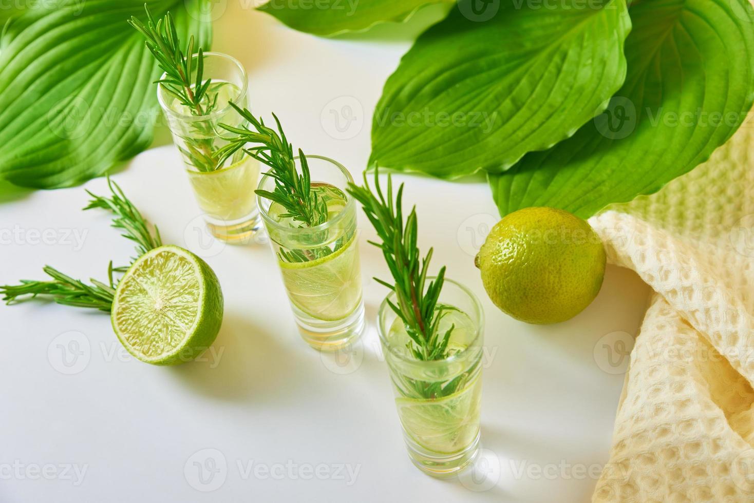 Drink with lime and rosemary on table photo