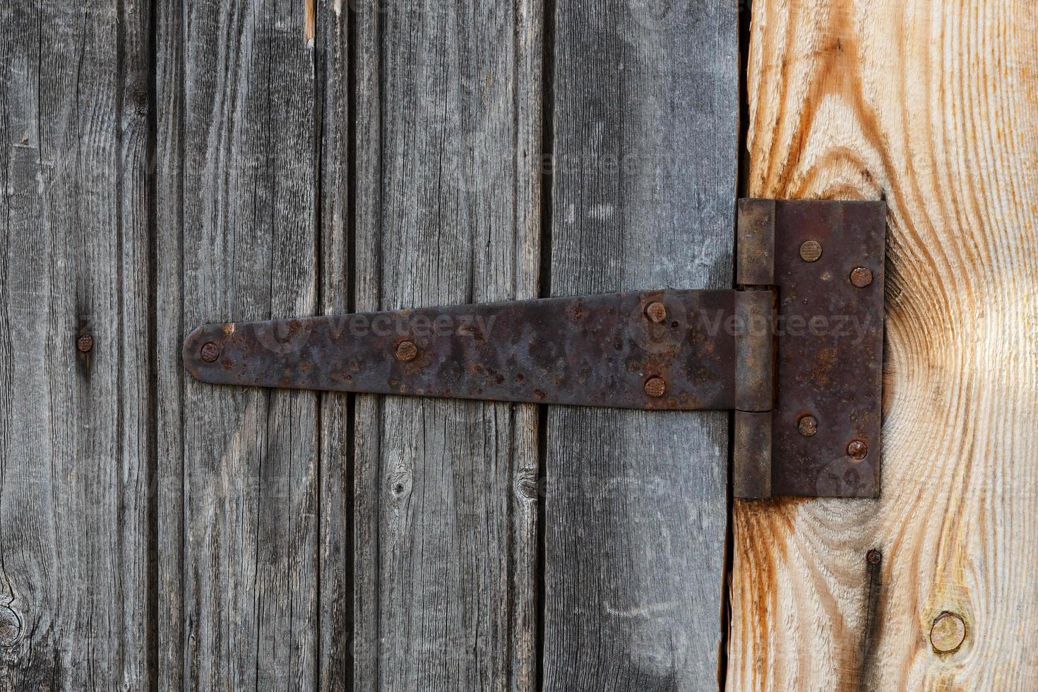 rusty metal door hinge. Door hinge on a wooden wall. photo