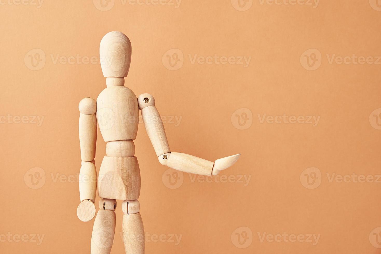 Wooden doll on beige background photo