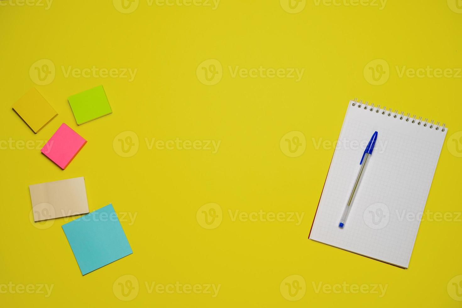 Notebook and pen on a yellow background. Top view with copy space. Stationery photo