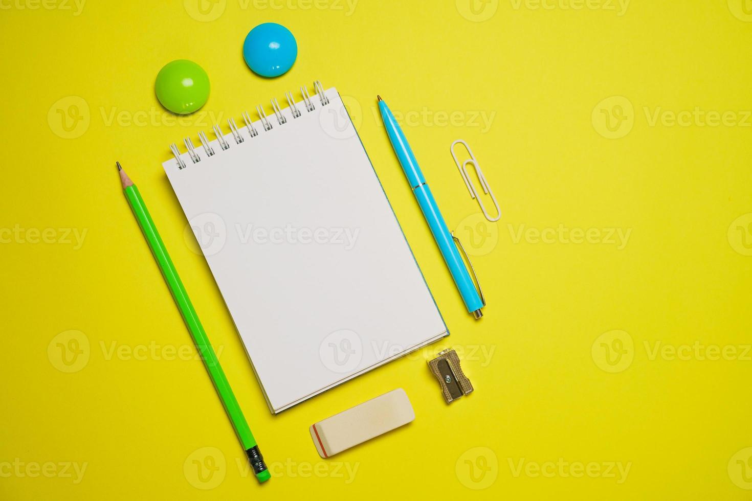 Top view photo open notepad ballpoint pen on yellow background with copy space.