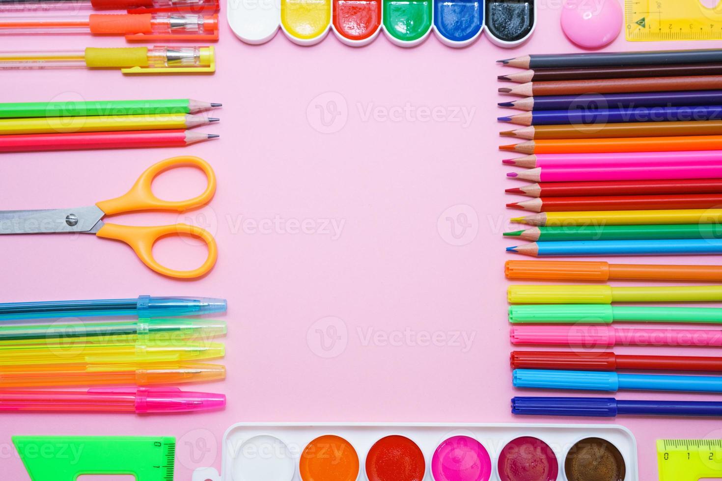 papelería escolar lápices de pintura de colores y bolígrafos sobre fondo rosa en forma foto