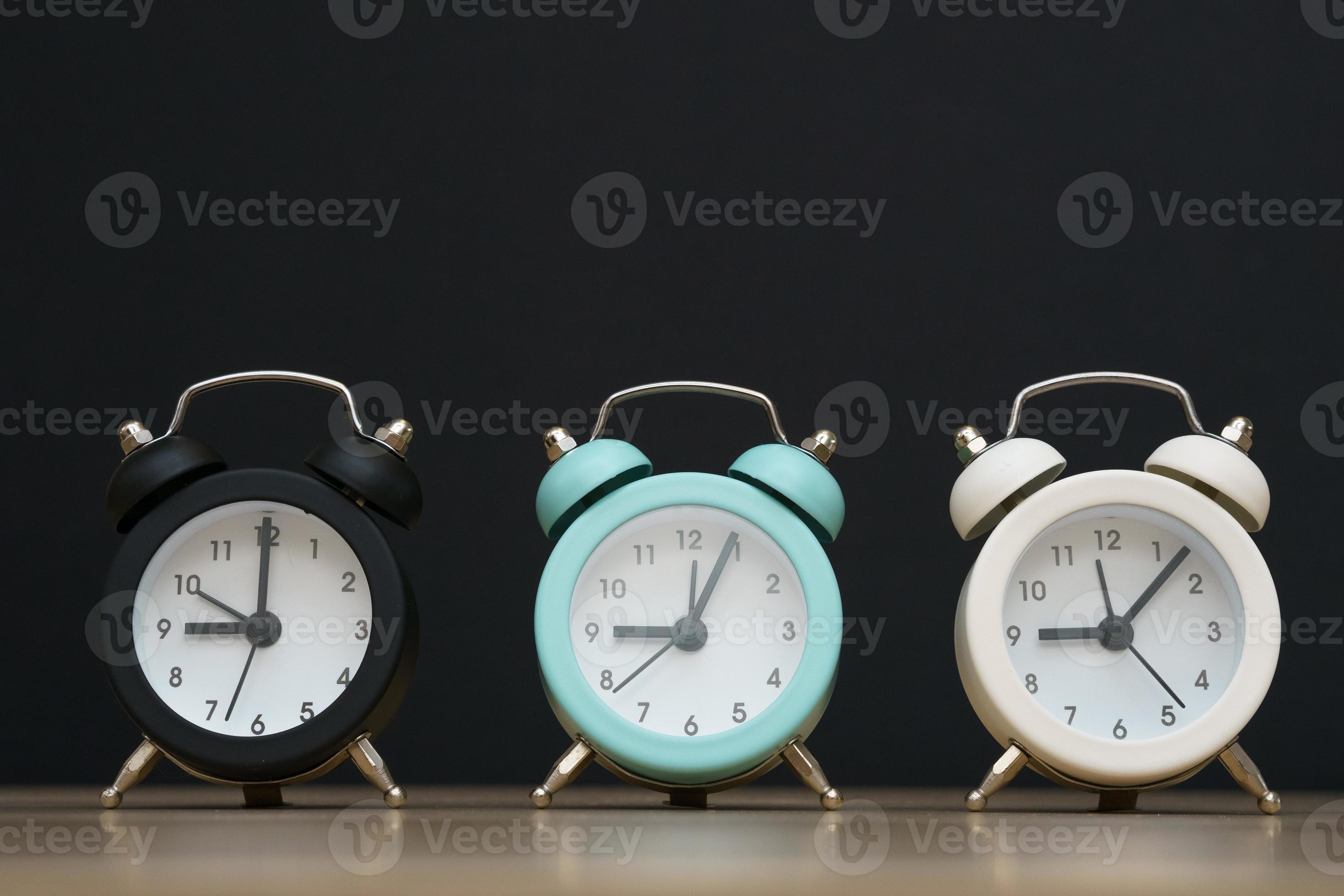 Three small alarm clocks black blue and white show nine o'clock, stand 13226809 Stock Photo at