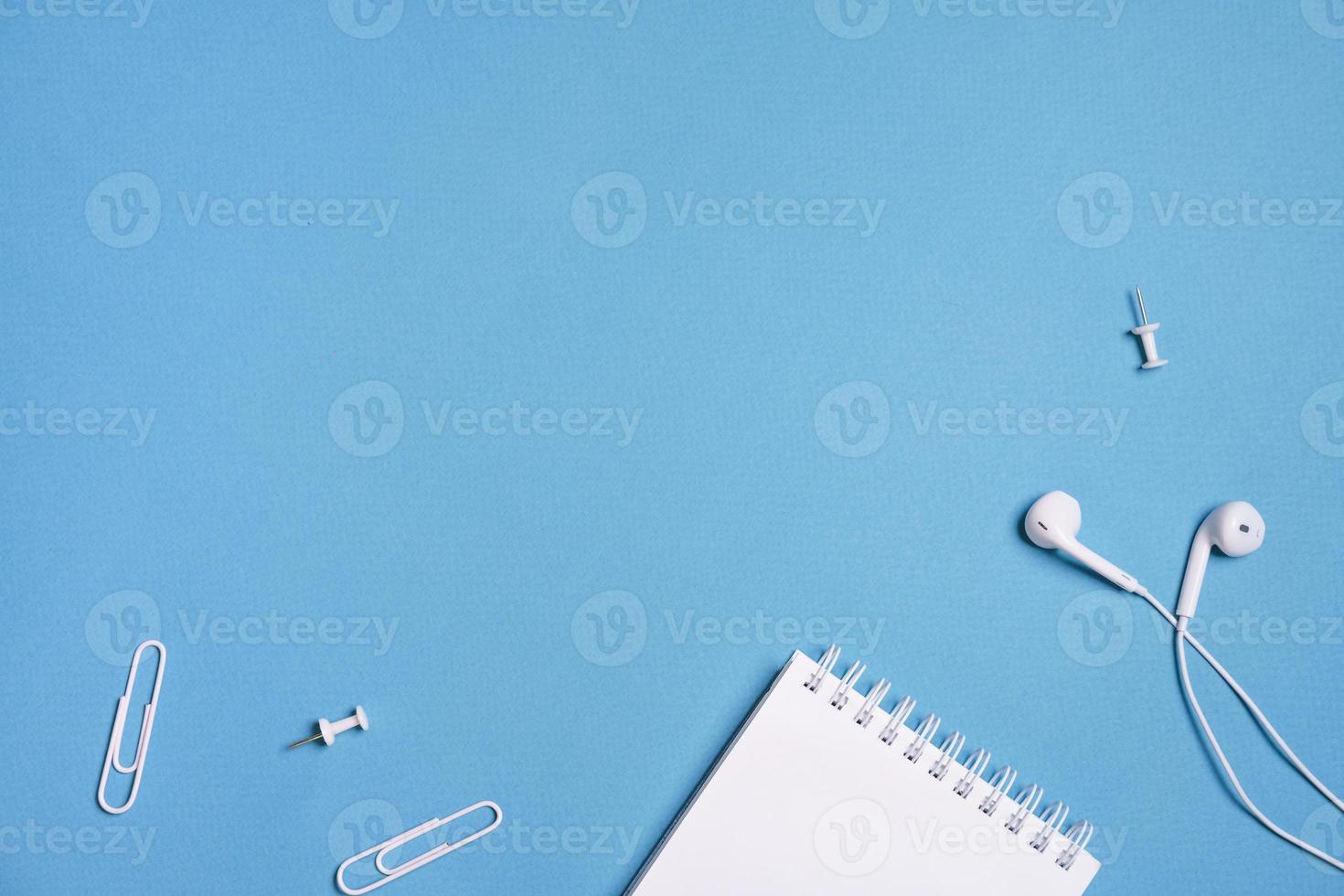Headphones, open notebook Music concept. Top view with copy space on blue photo