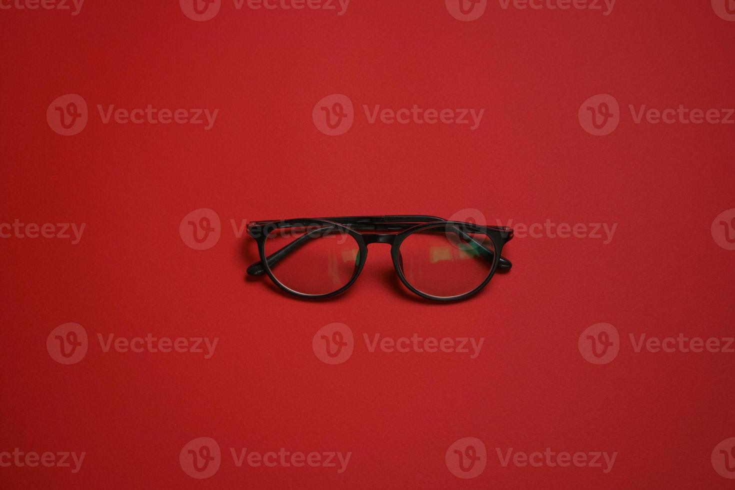 Plastic card style fashion glasses style isolated on dark red background photo