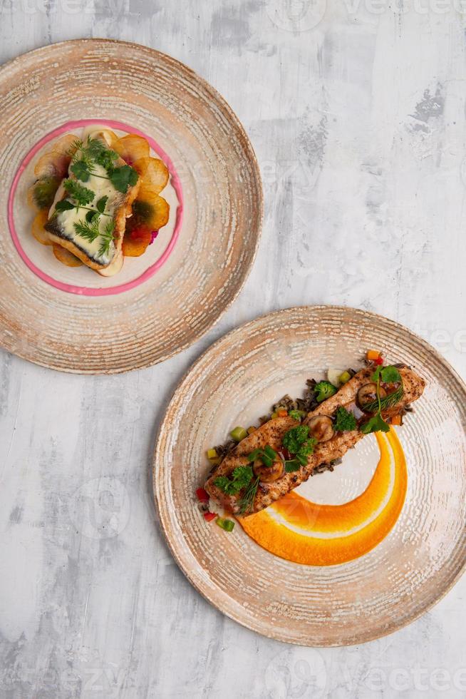 A top view of two beautiful and tasty food on plates isolated on a grey background photo