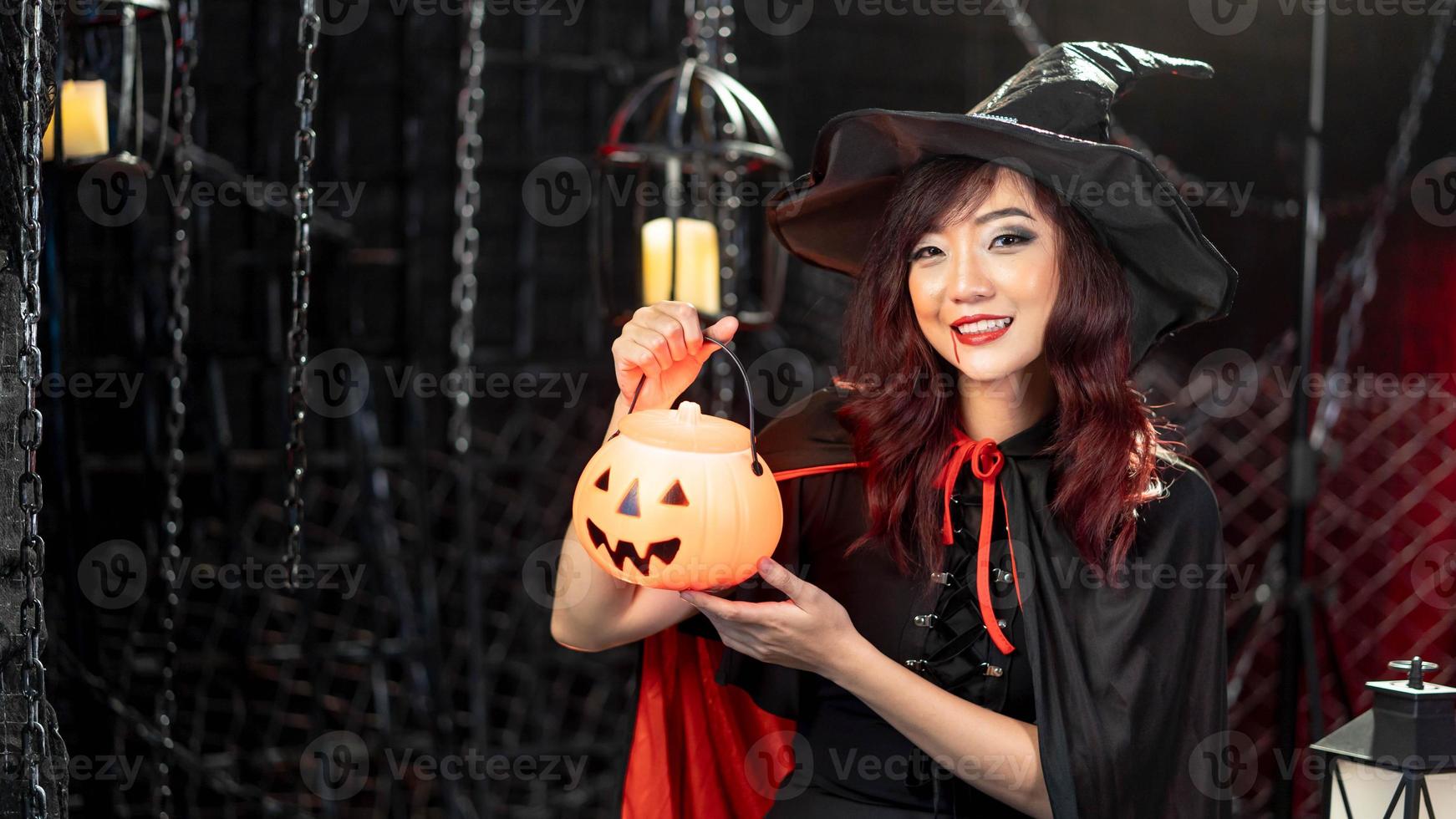 Portrait Beautiful young asian woman wear halloween costume holds a pumpkin in halloween. Emotion smile photo