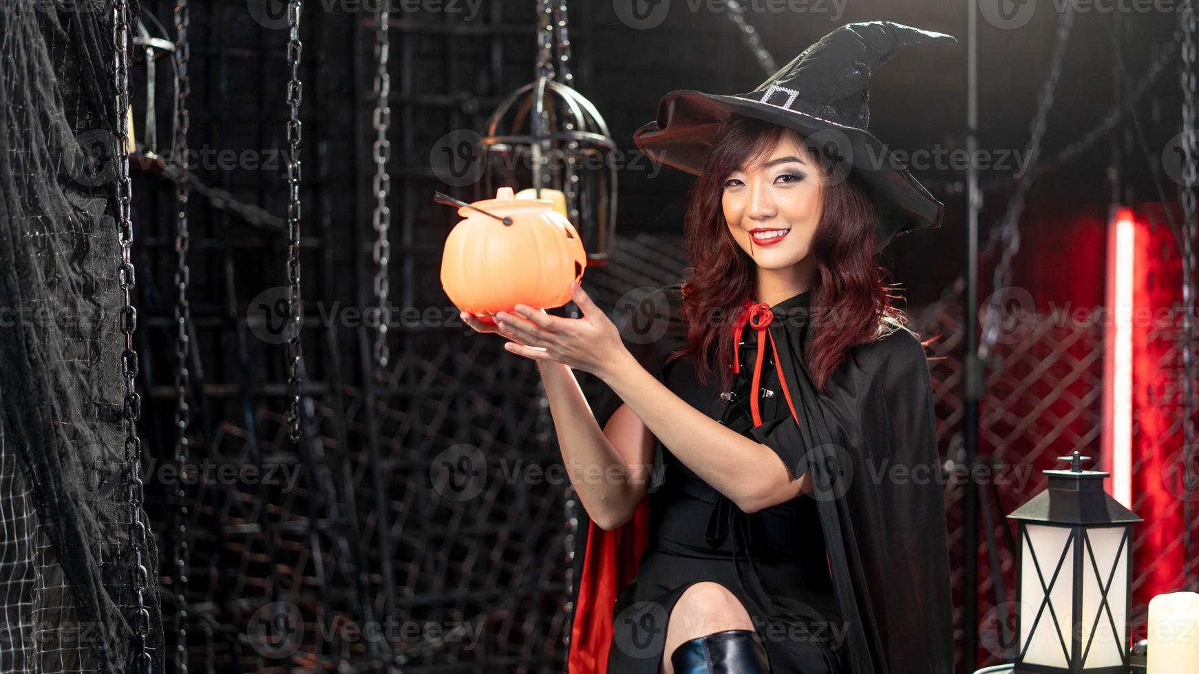 hermosa mujer joven en traje de bruja con calabaza de halloween en el tema de halloween. foto