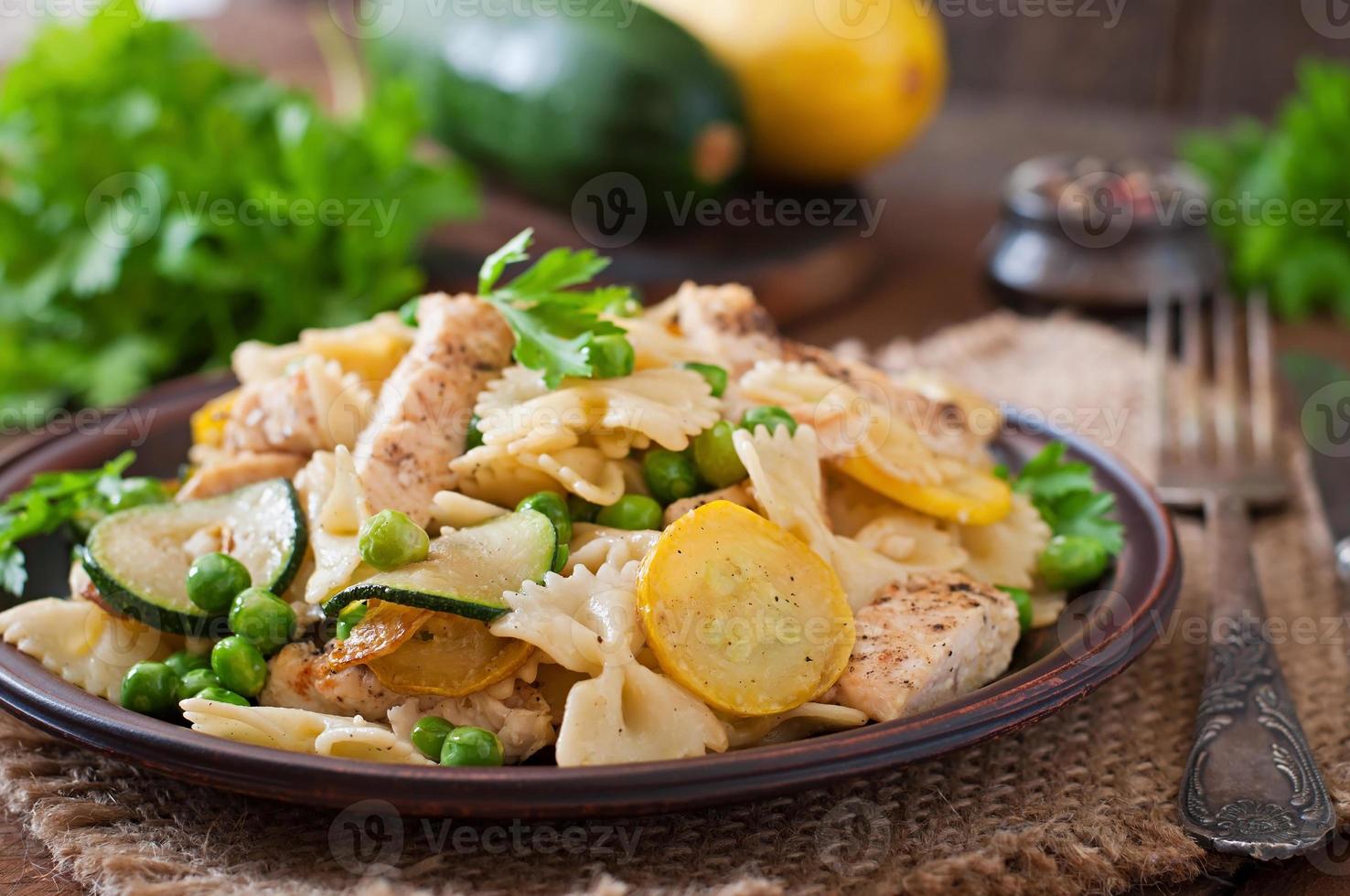 Pasta with zucchini, chicken and green peas photo