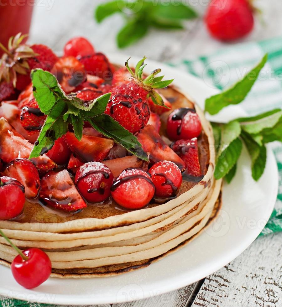 Pancakes with berries and strawberry smoothie in a rustic style photo