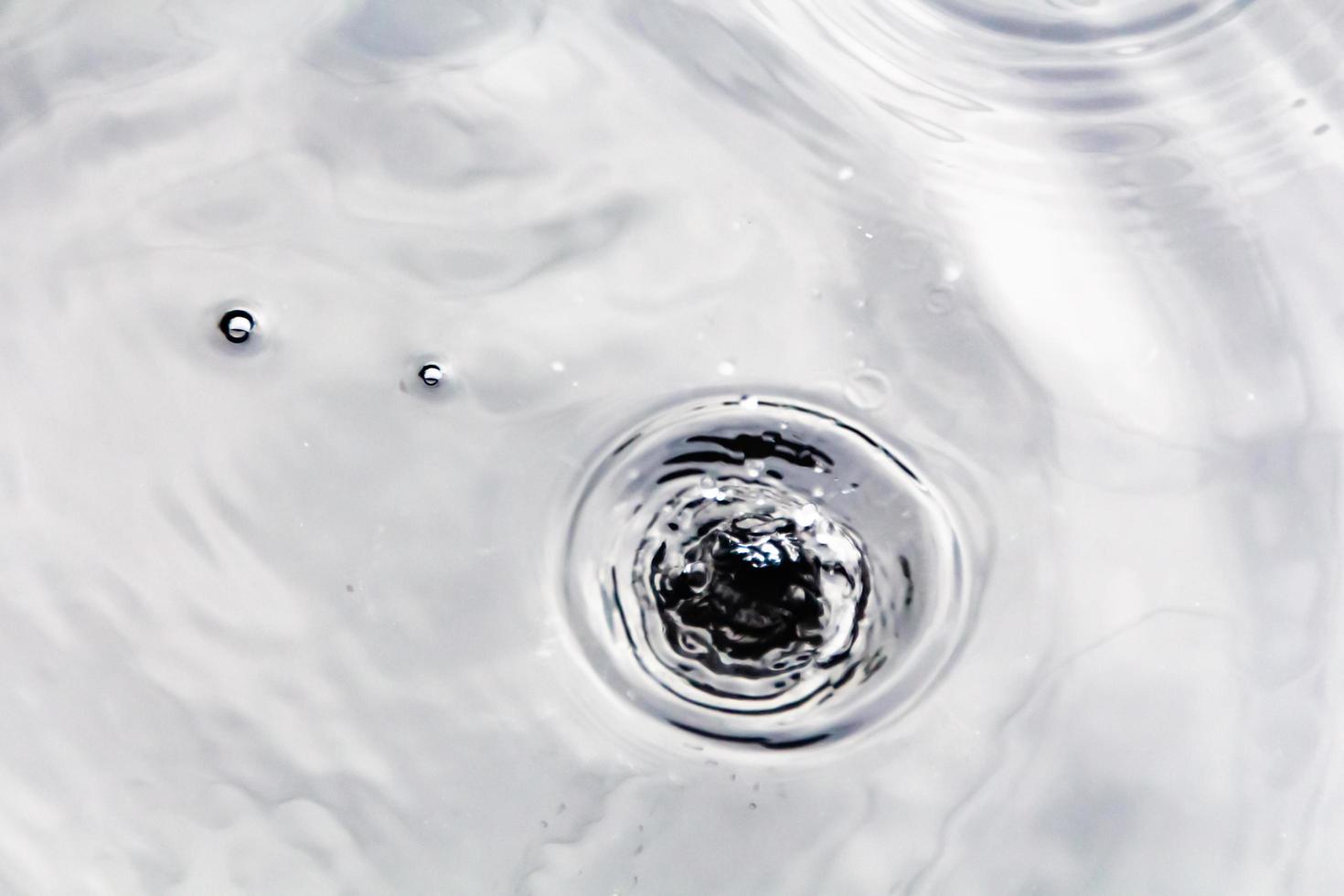 Water droplets or water beads fall on the water surface causing the water surface to disperse and foam. photo